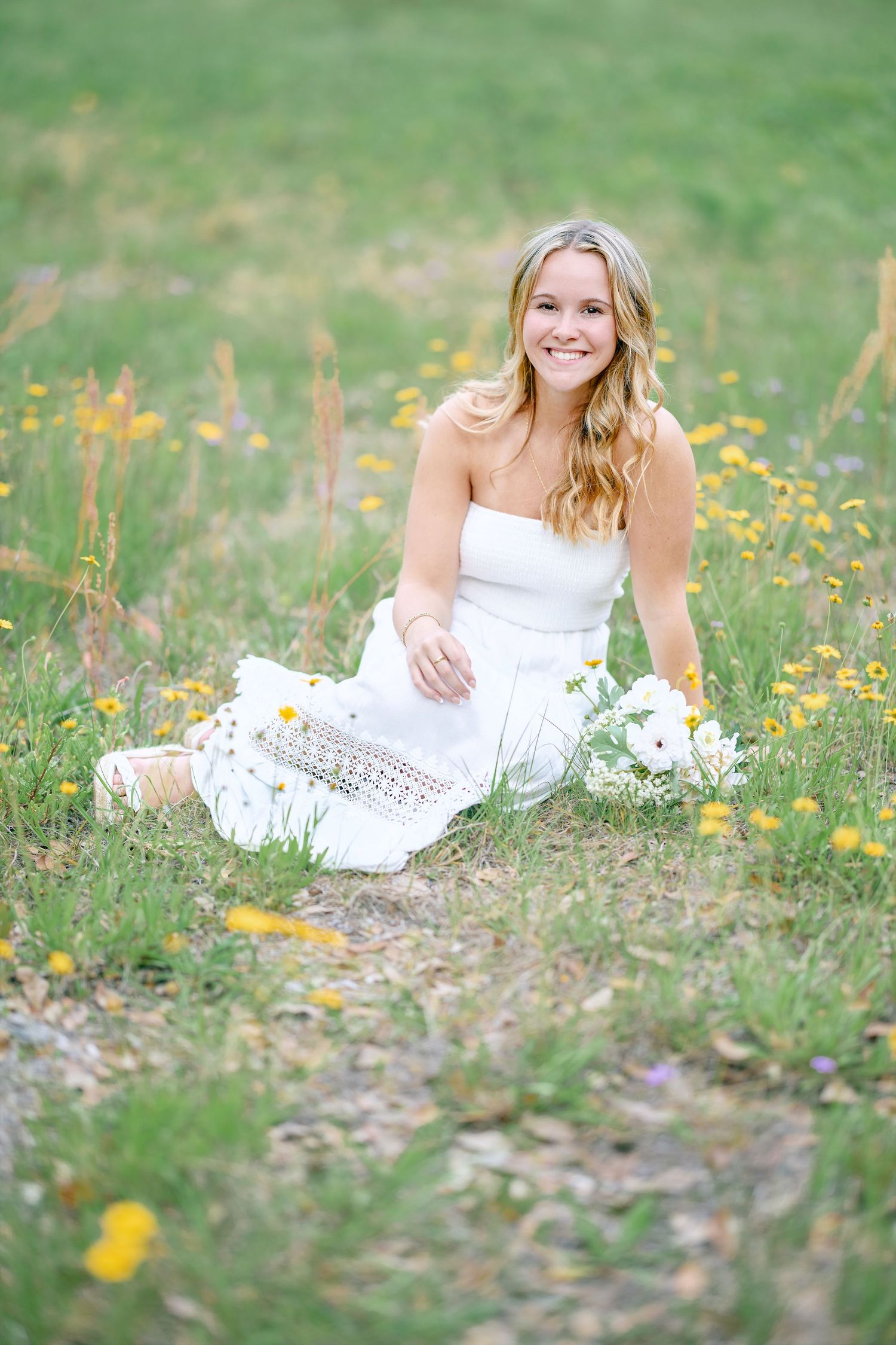 Summer portrait session in field with white dress and wildflowers.