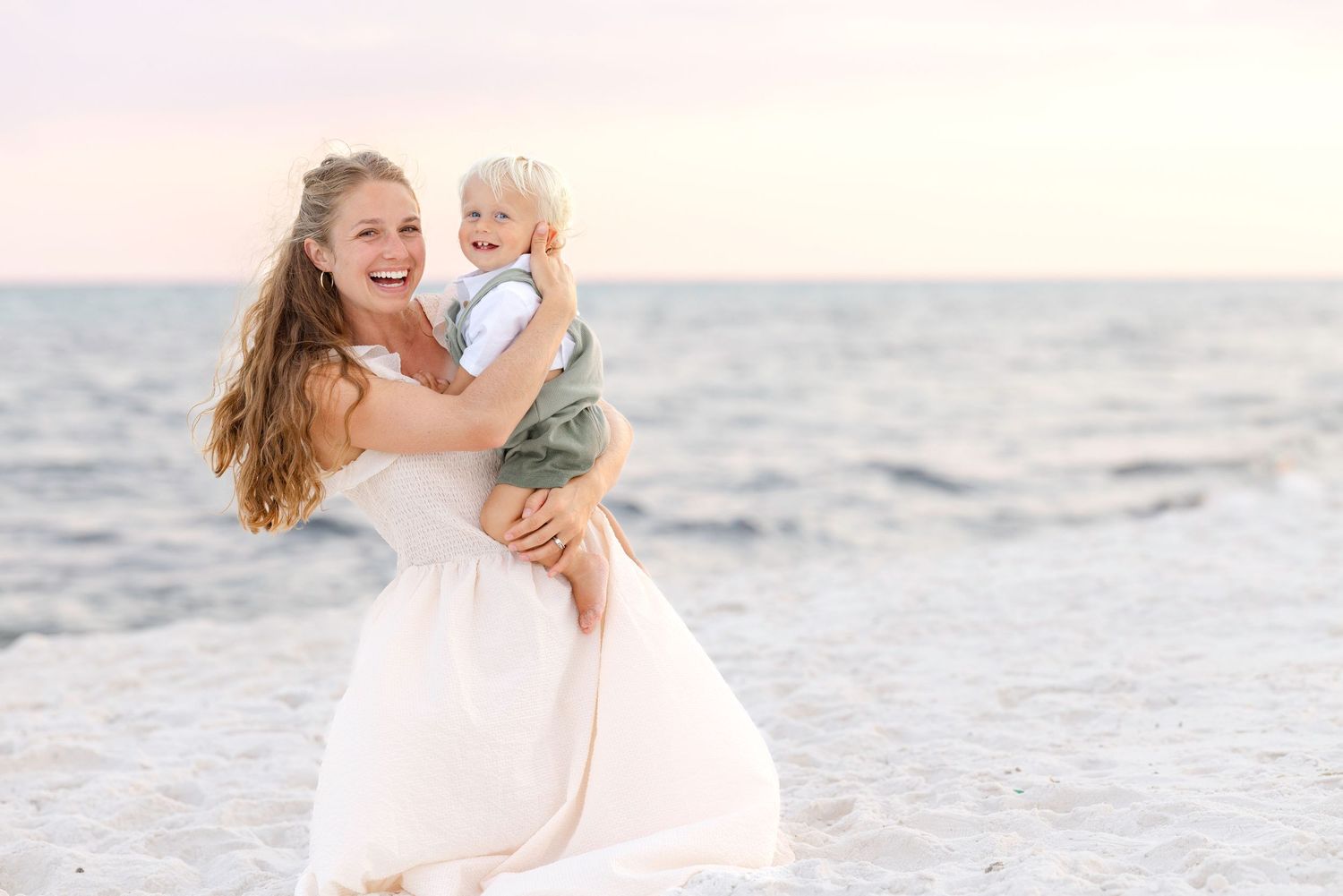 Family spending time together on pristine white sandy beach at sunset.