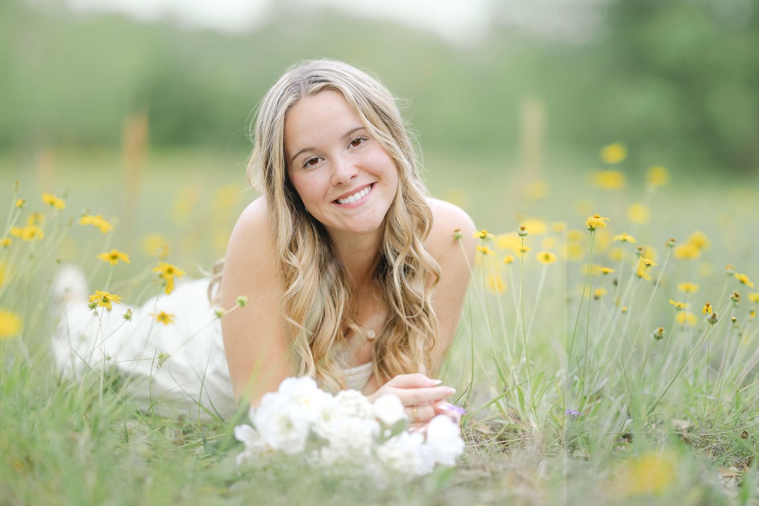 Floral-themed portrait photography outdoors with wildflowers and soft natural lighting in a grassy meadow field.