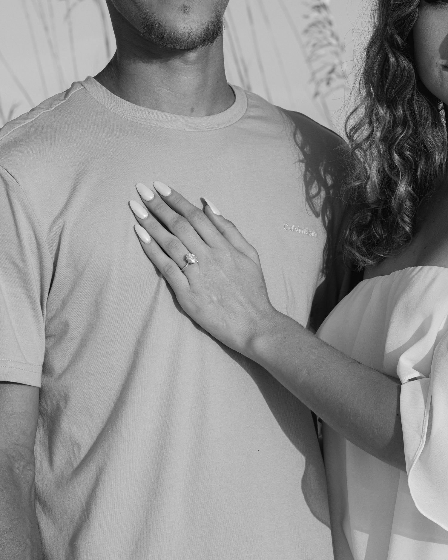 A close-up engagement ring series showing someone displaying their hand with a diamond ring against a white background.