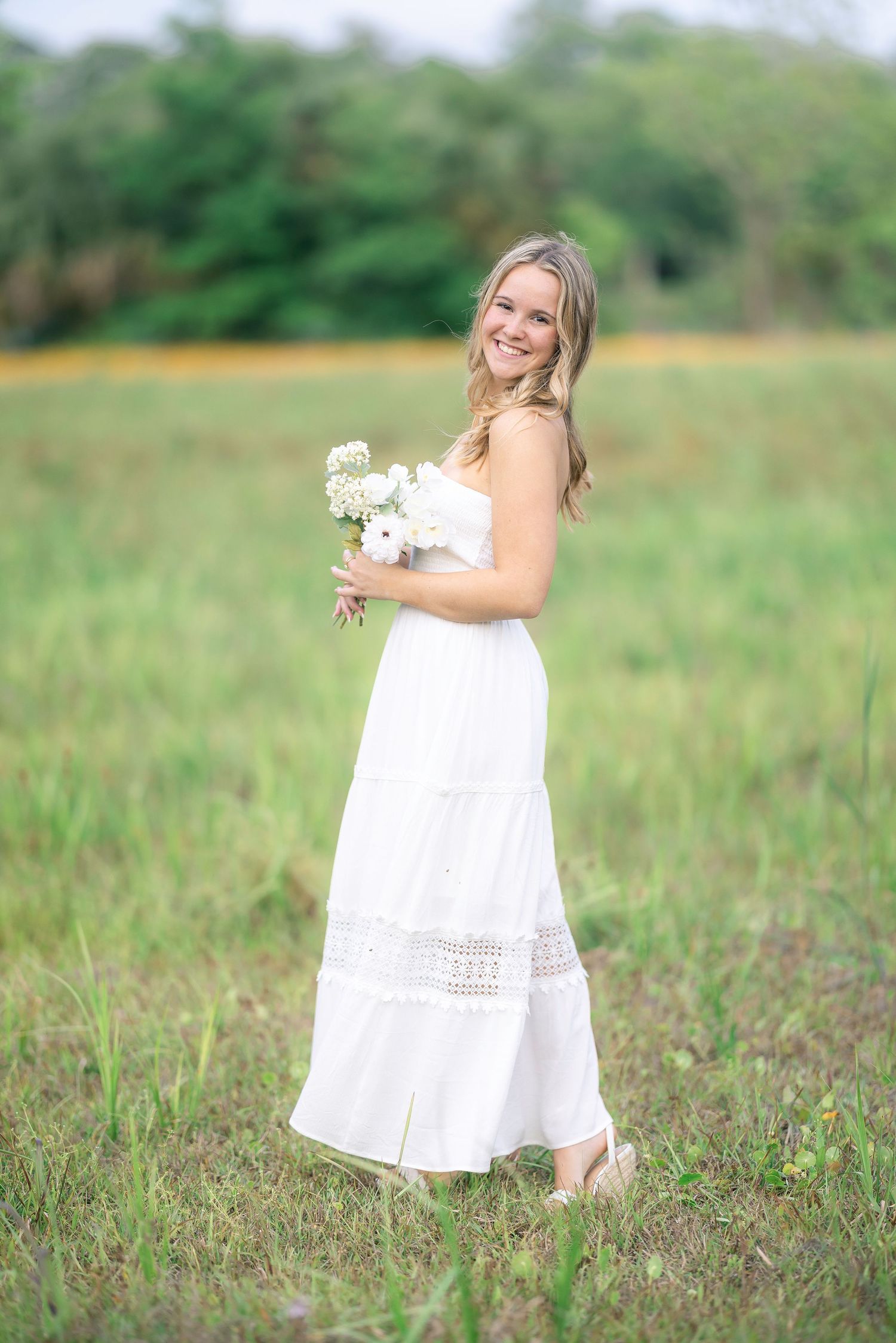 White lace dress movement captured in a series of dreamy outdoor photos in a grassy field.
