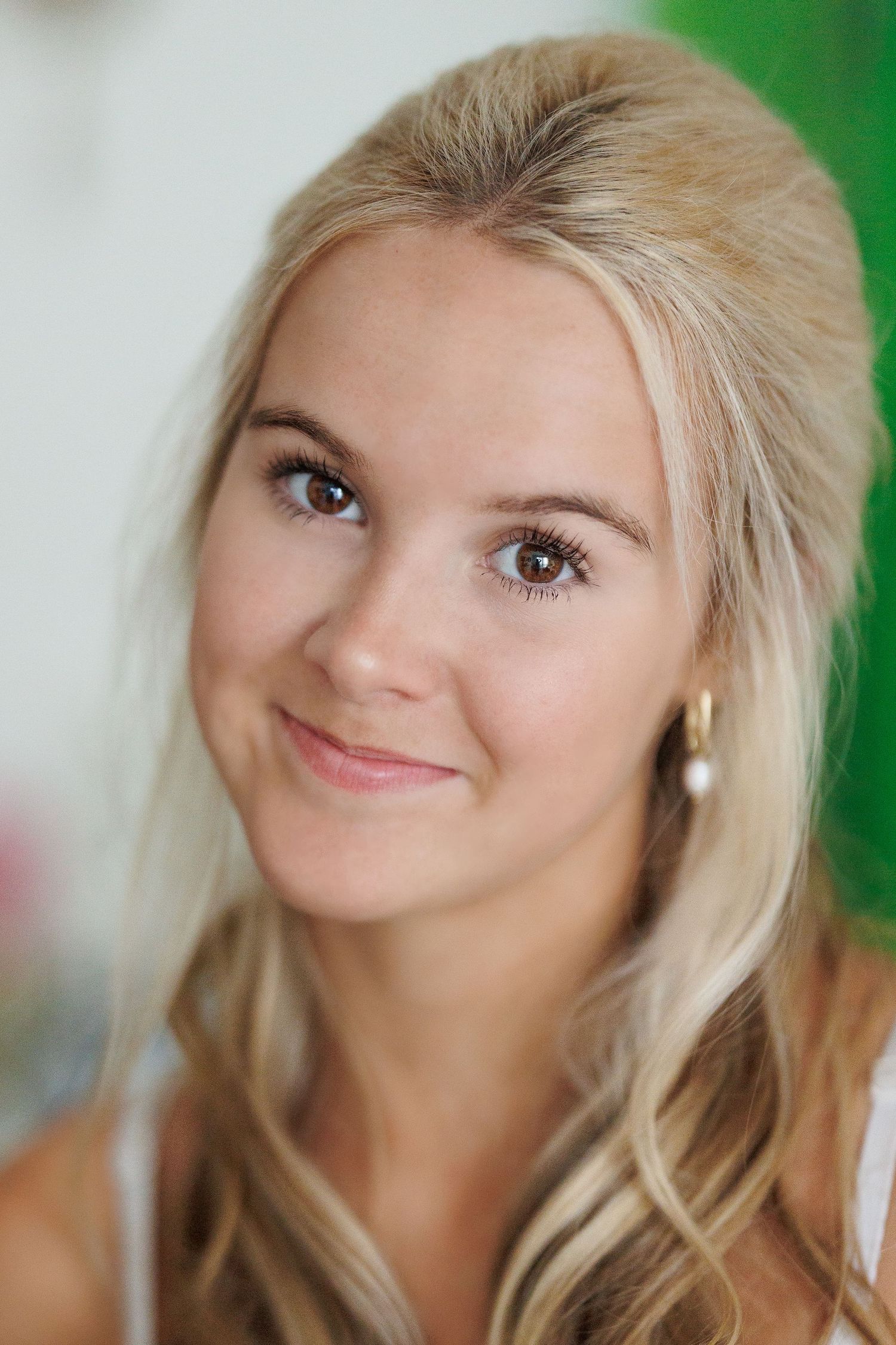 Portrait photograph featuring soft lighting and blonde hair against a green background.