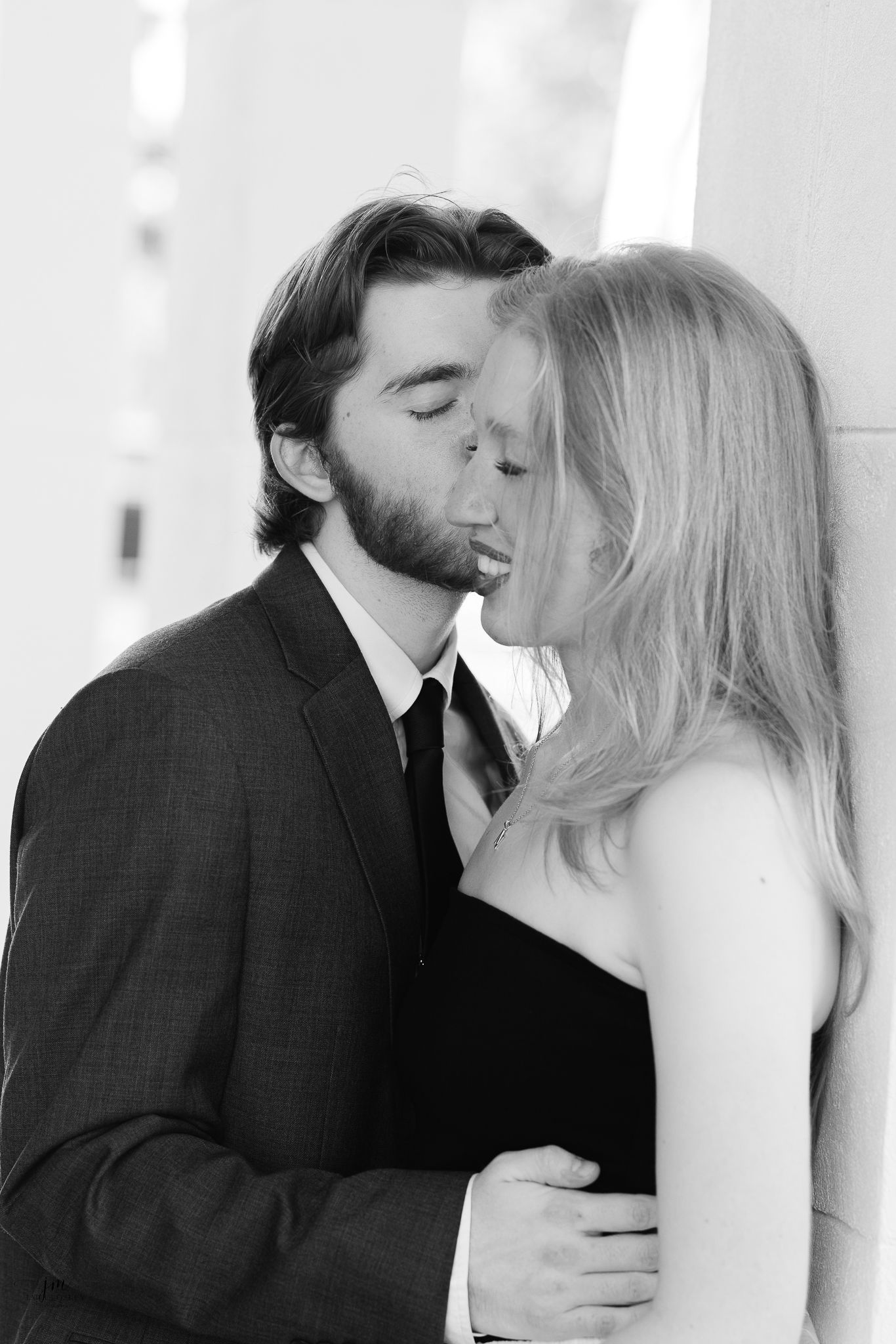 Black and white photo series capturing tender kisses between a couple in wedding attire.