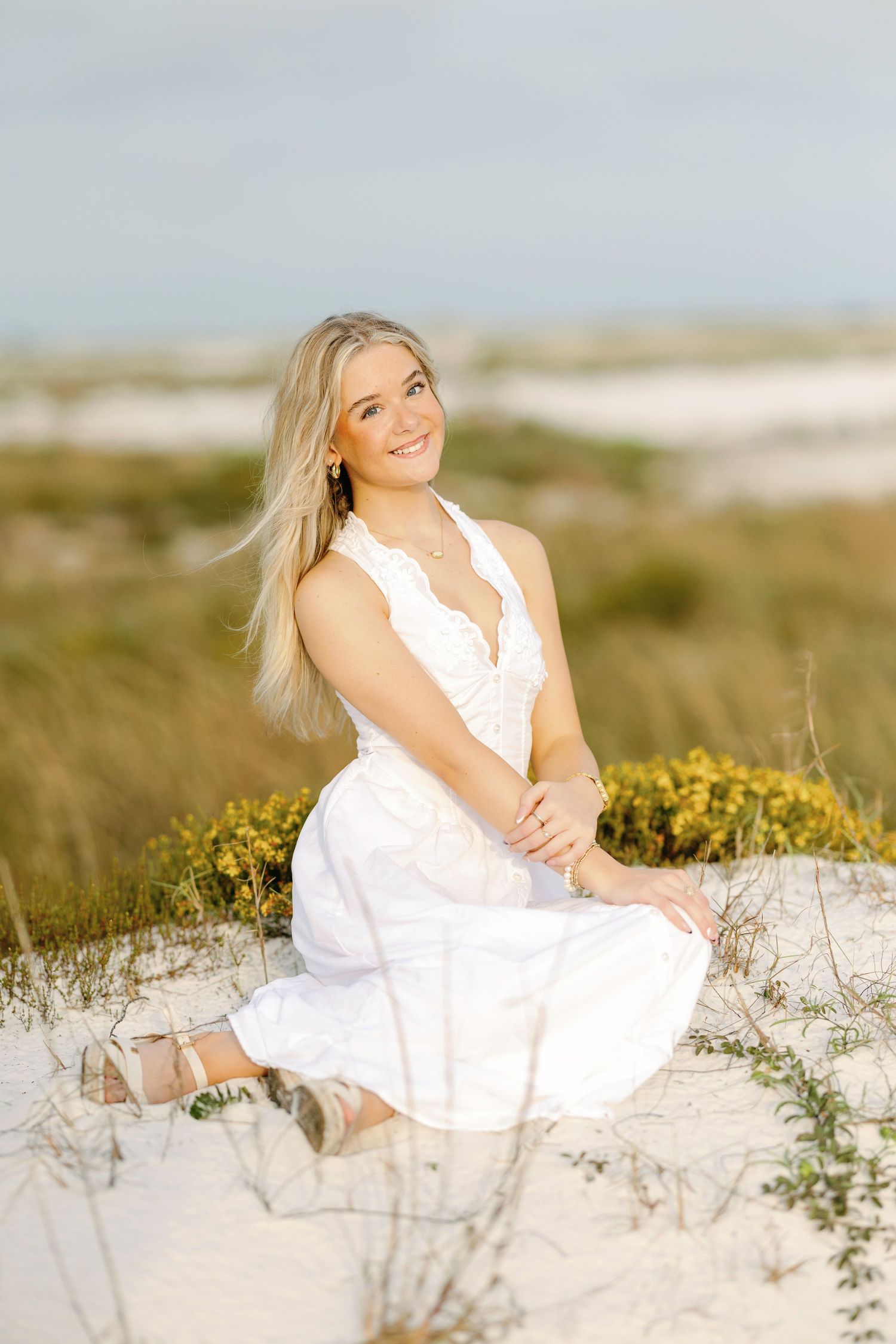 Candid beach photography sequence featuring someone in a white sundress posing on sandy dunes.