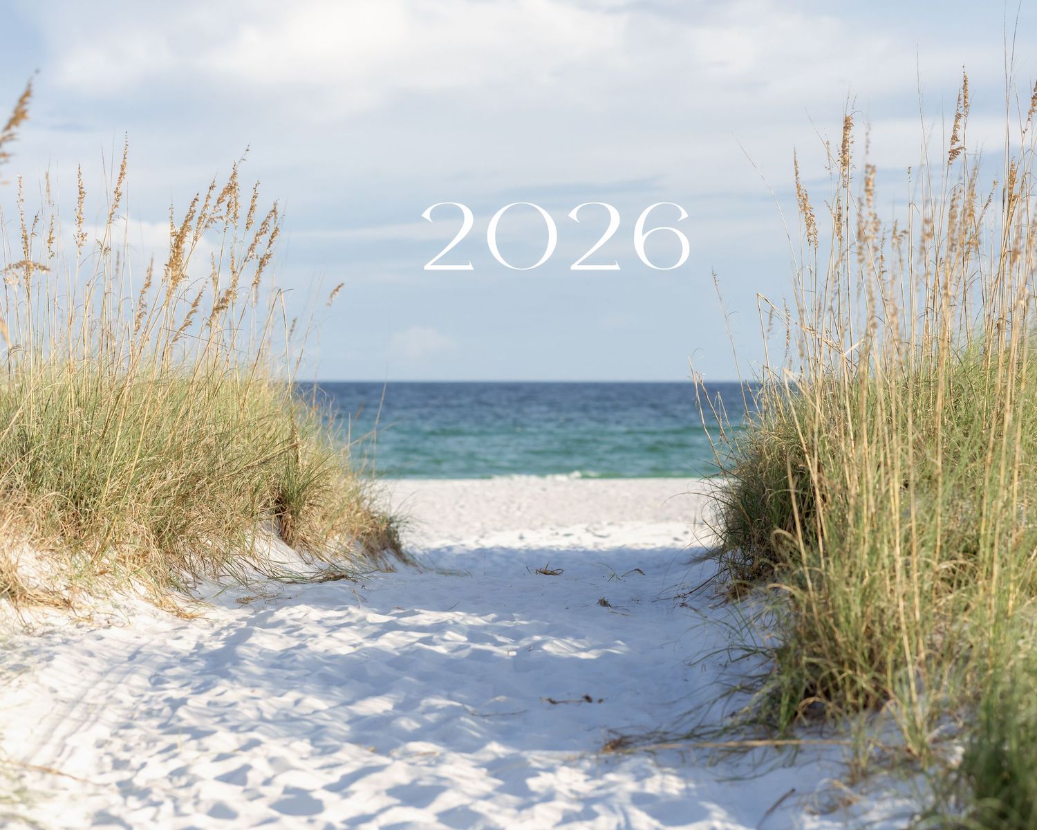 Sandy beach path flanked by sea oats leading to turquoise water with 2026 text overlay.