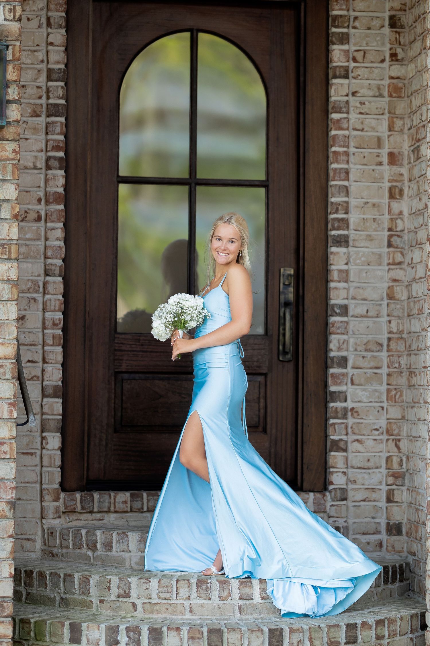 Person in flowing light blue formal dress twirls and poses on brick porch in three-panel sequence.
