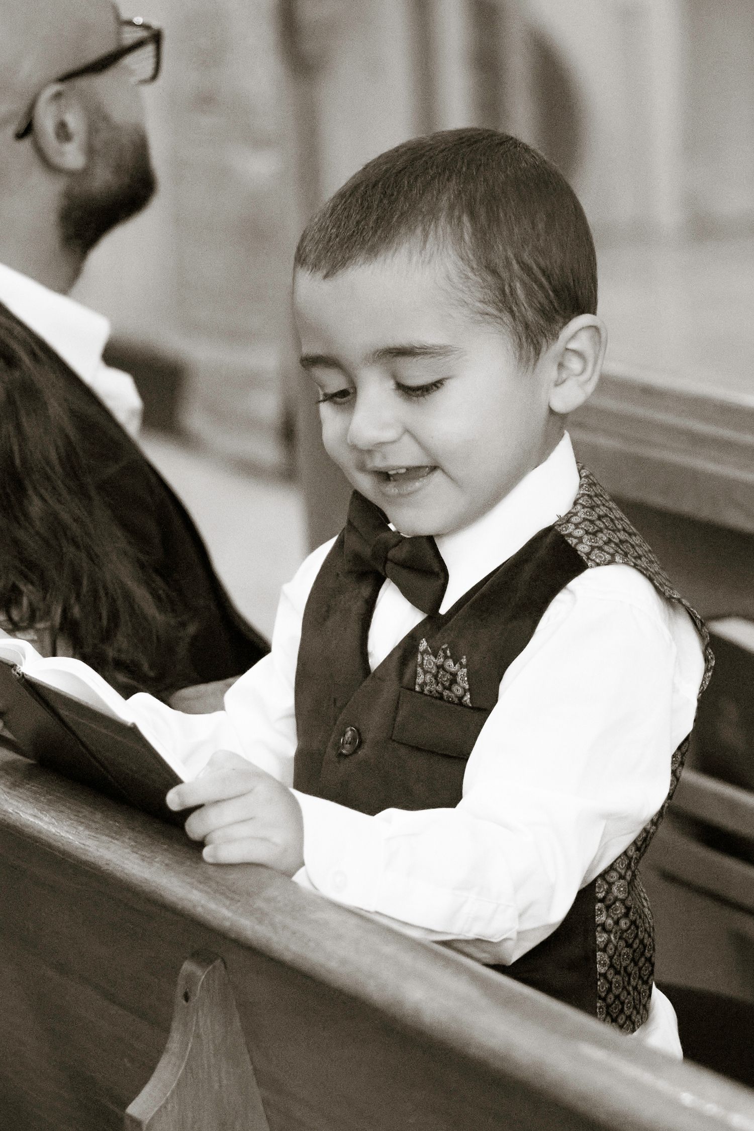Black and white photo series of a young child in formal attire writing at a desk in a classroom setting.