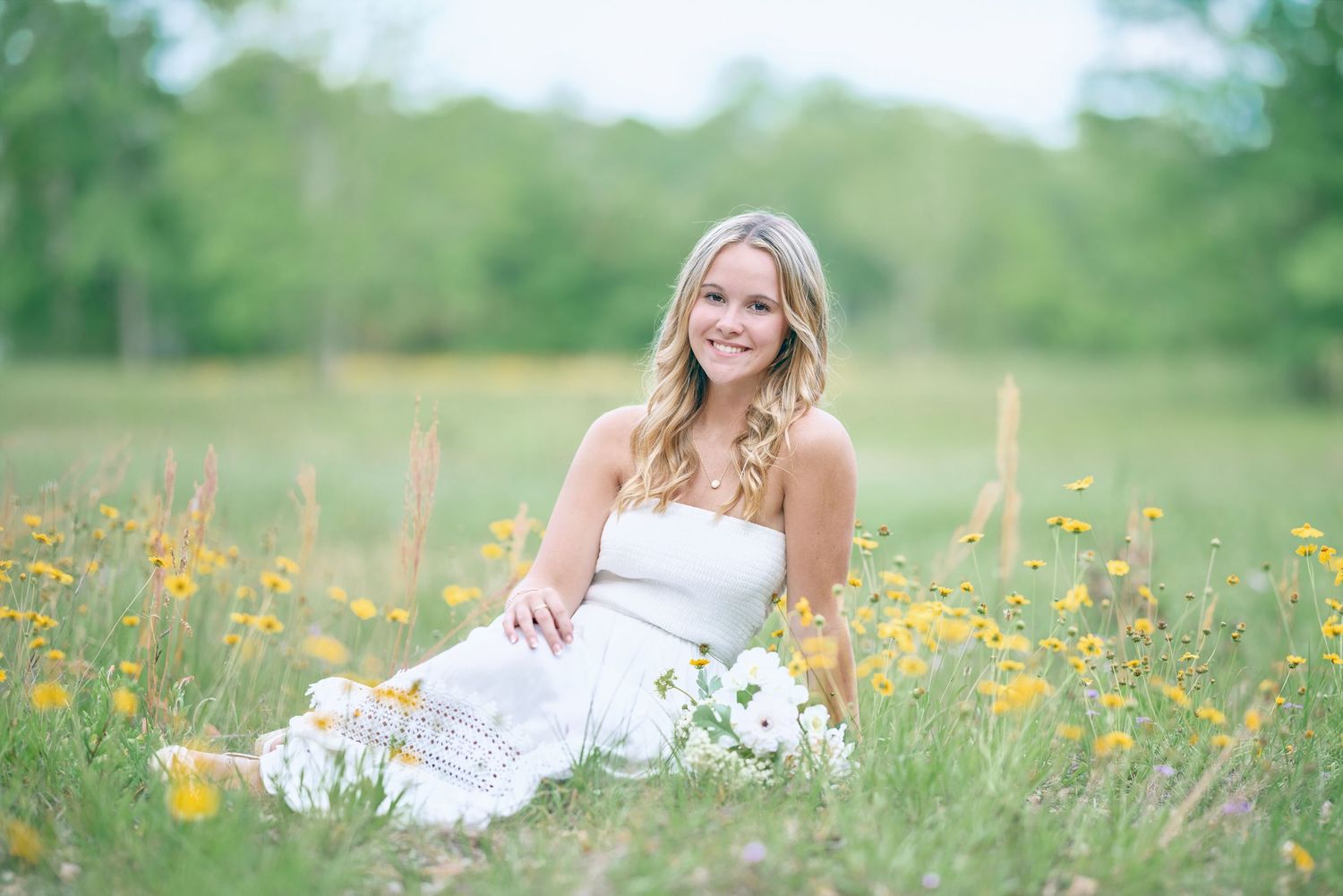 White sundress photoshoot in field of yellow wildflowers with natural lighting.