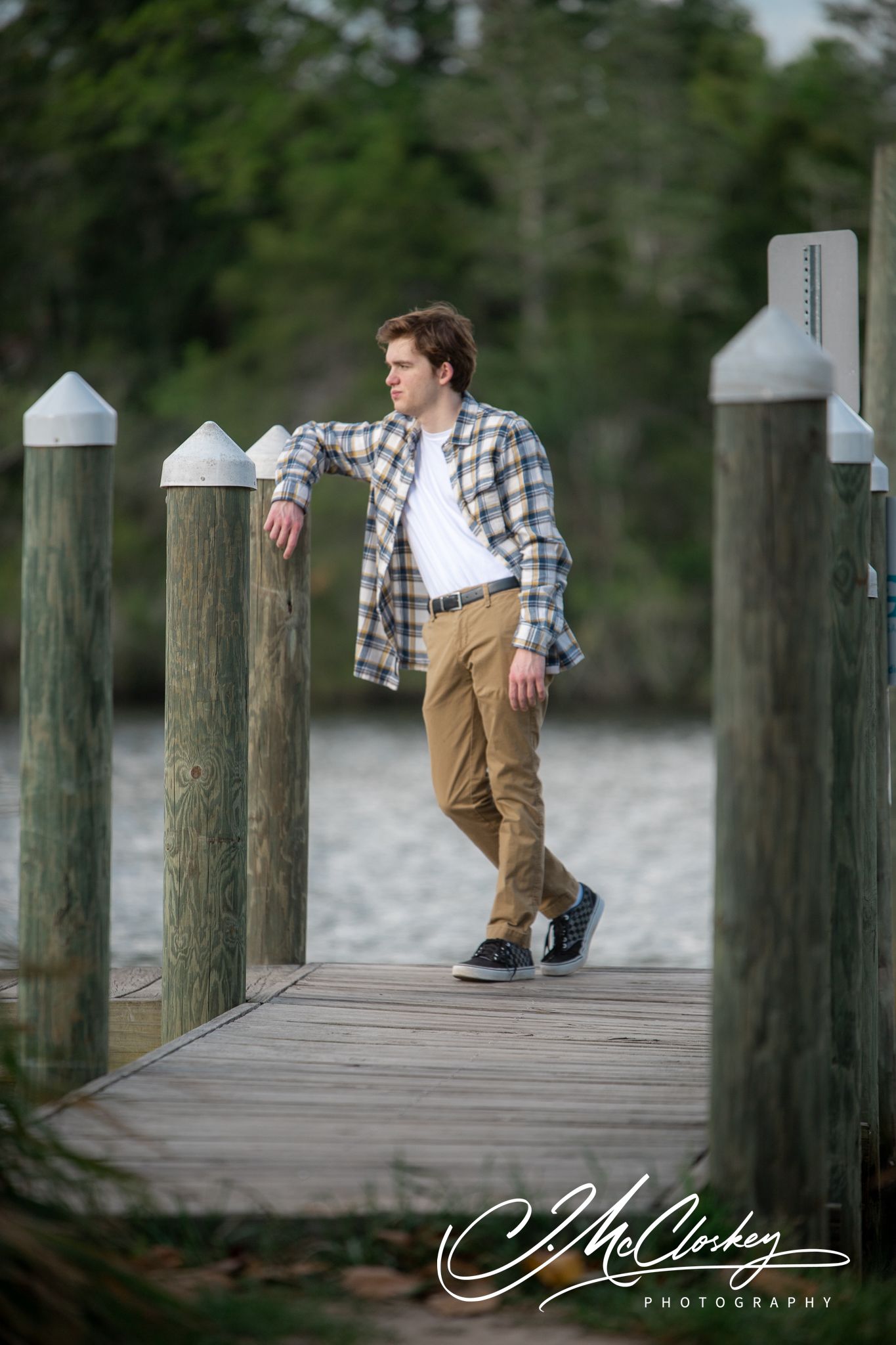 Four sequential shots of a man in plaid shirt and khakis sitting and posing on a wooden dock over water.