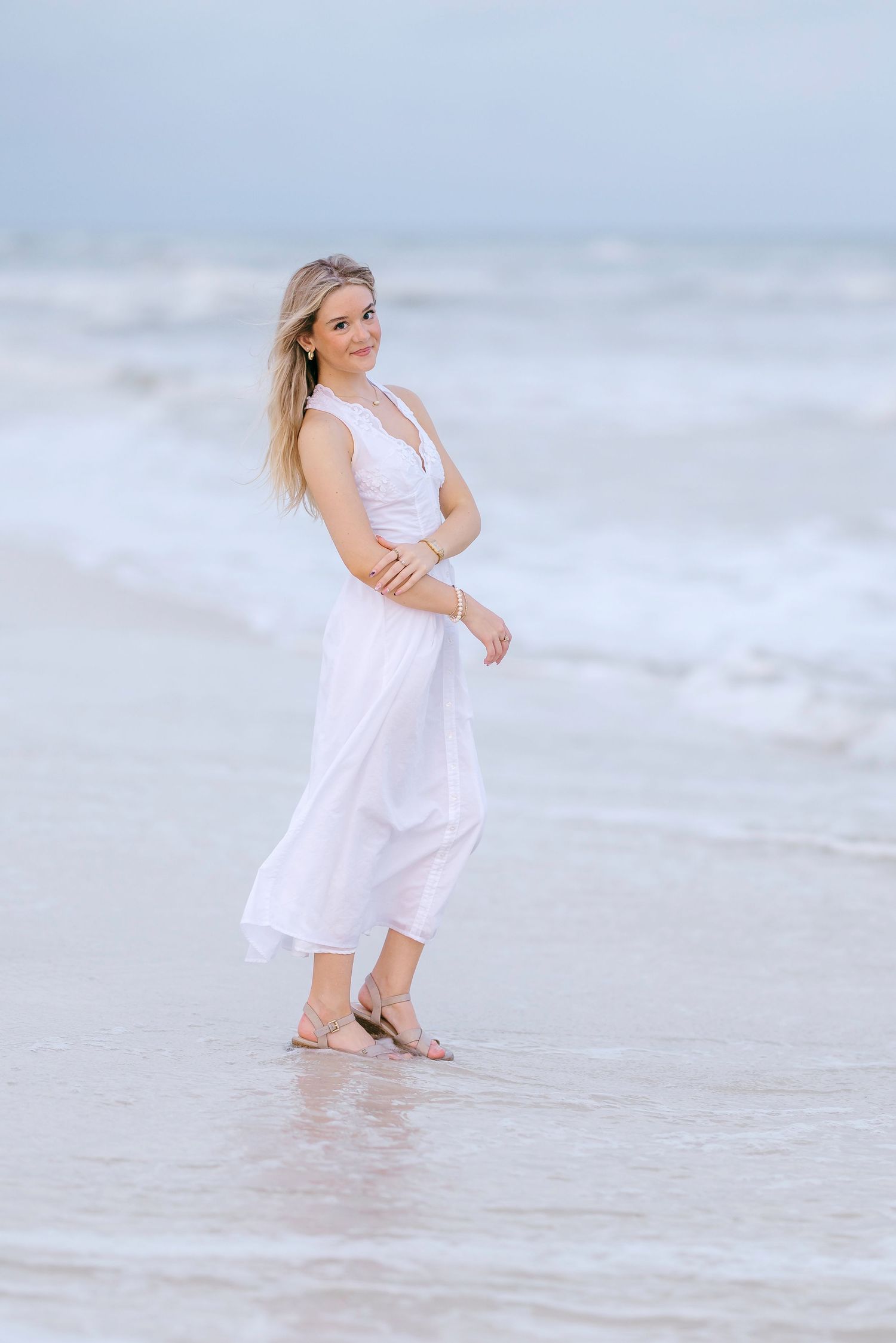 Collection of soft beach portraits featuring white sundress and gentle waves at shoreline.