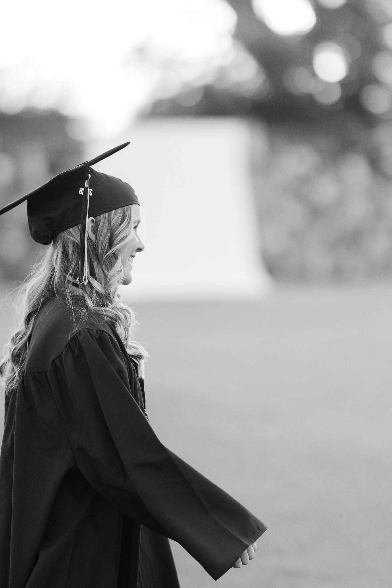 A black and white profile shot of a graduate in academic regalia.
