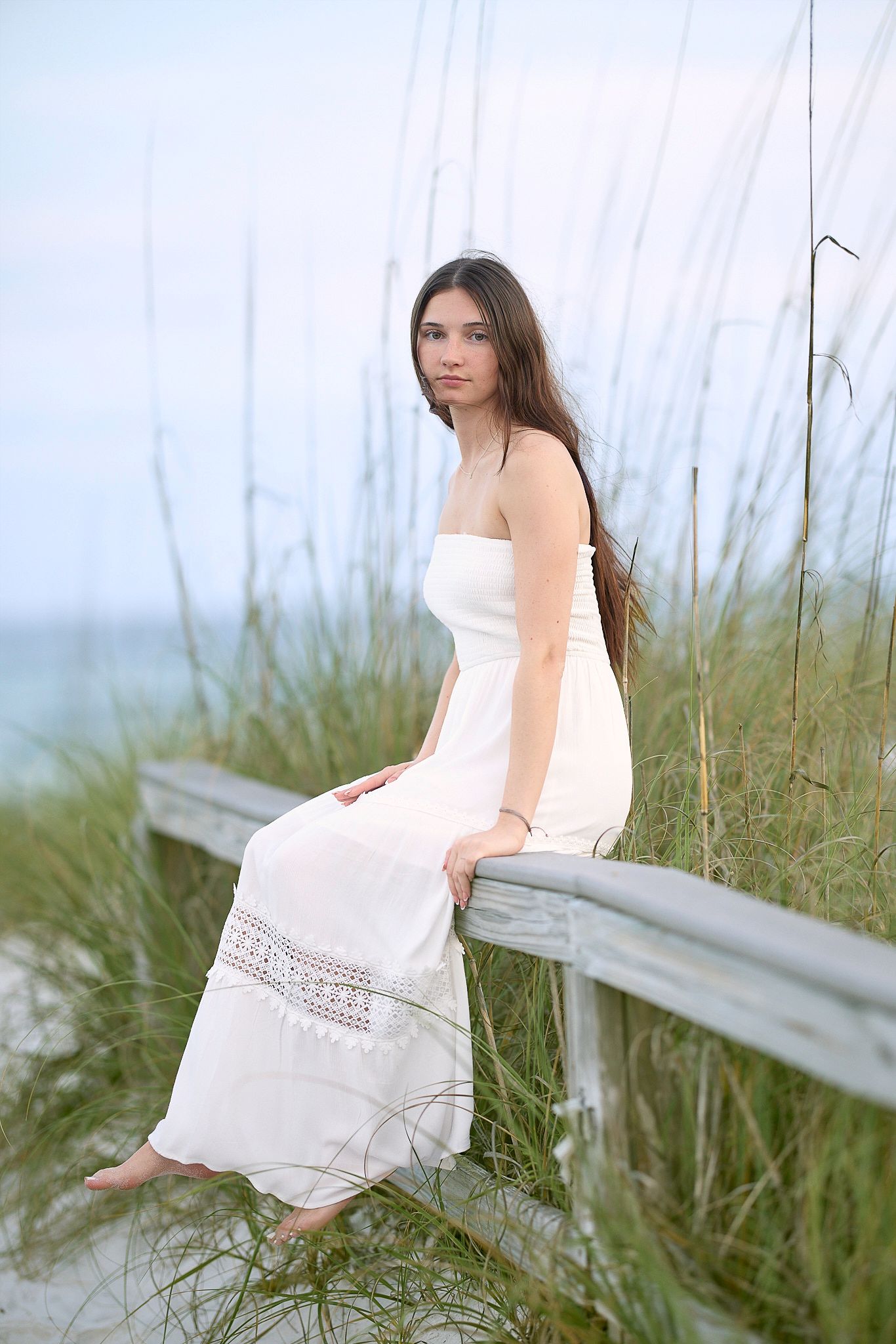 A series of photos showing a person in a white dress sitting among tall grass and beach dunes.