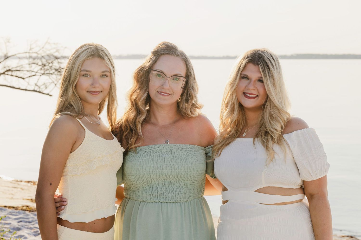 A series of five beachwear fashion photos showing people in soft pastel clothing posing together by the ocean at sunset.