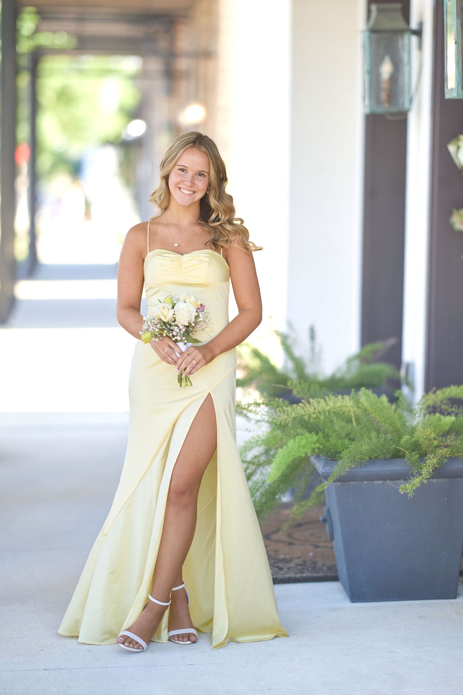 A yellow sundress flows elegantly in a series of poses on a bright patio.