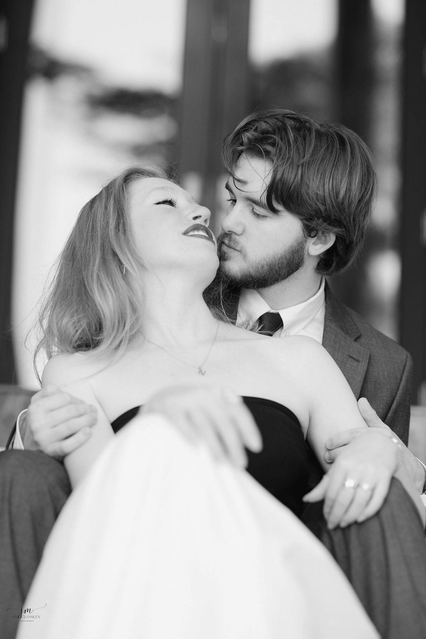 Black and white romantic portrait of a couple in an intimate pose outdoors.