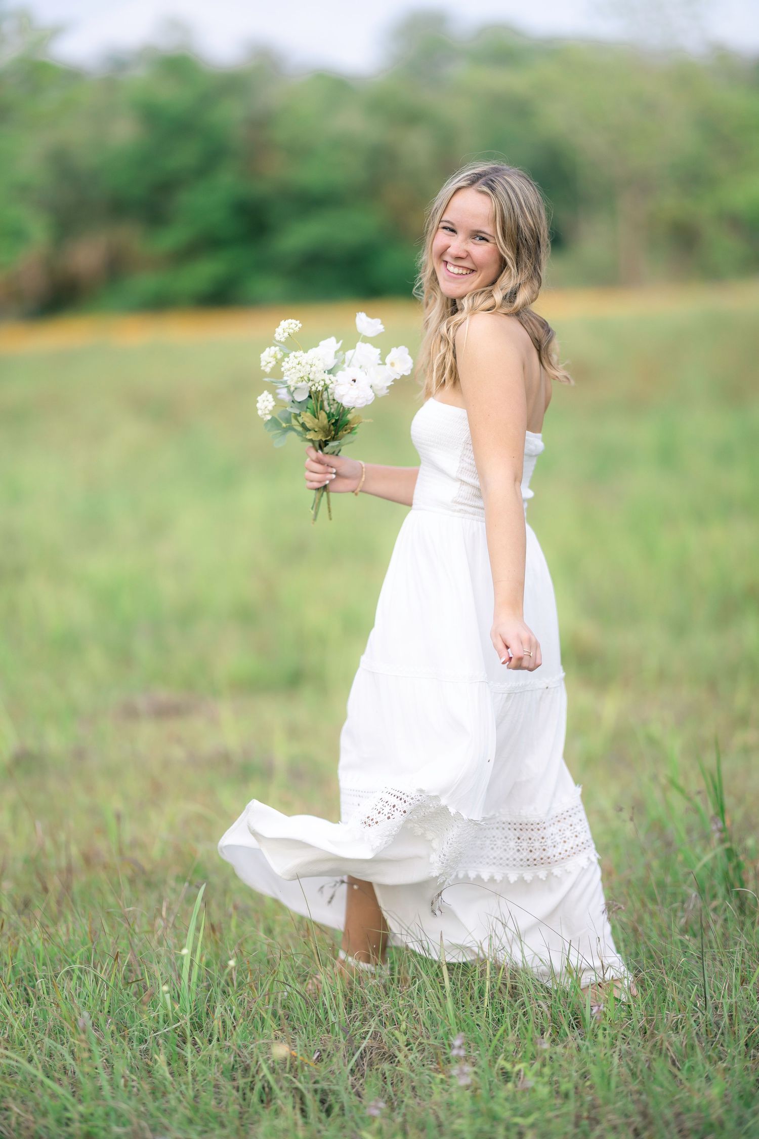 Ethereal white dress dancing through a summer meadow with delicate flower details.