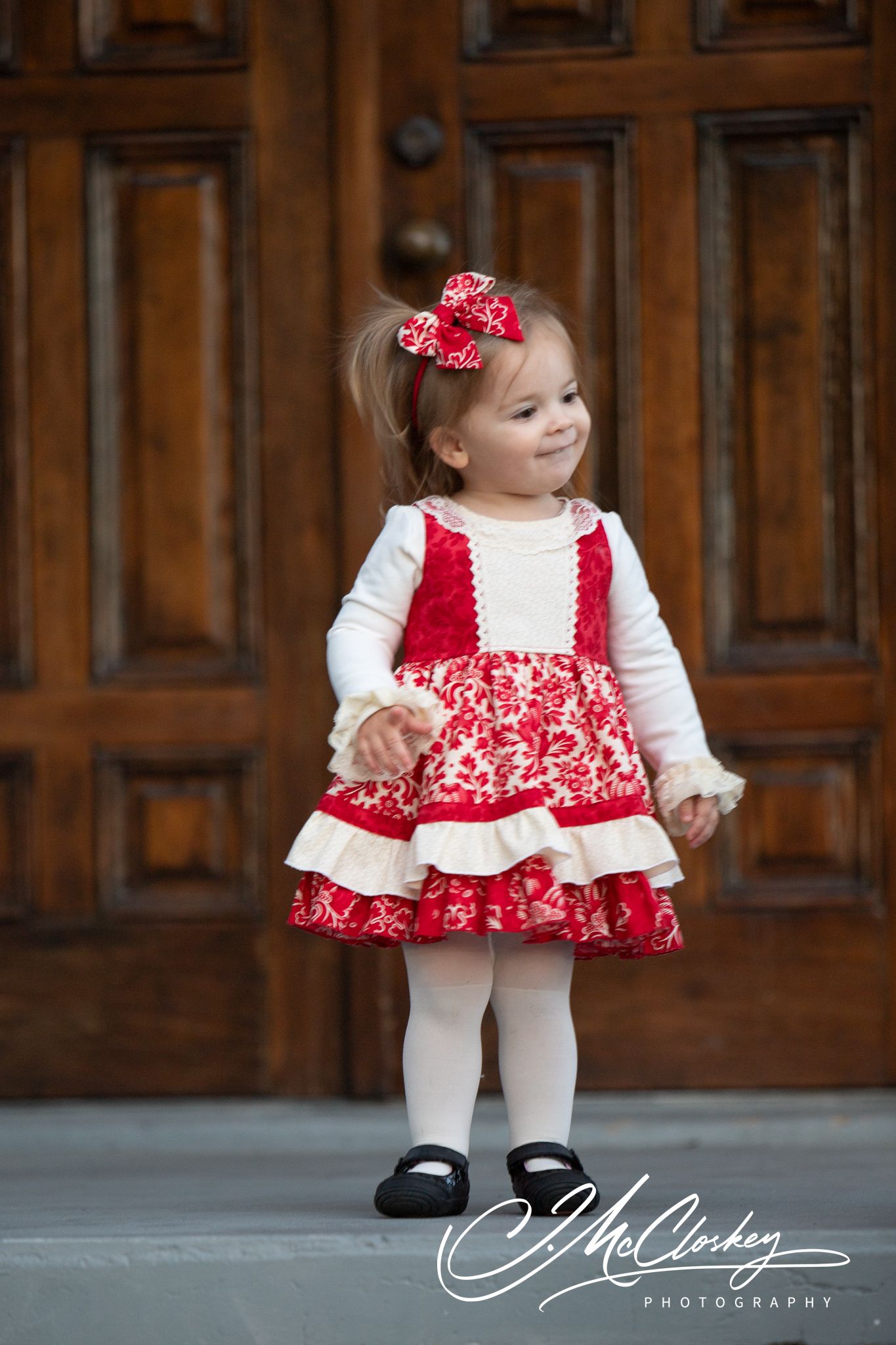 Sequence of photographs showing a child in a red and white floral dress with ruffles against a wooden paneled wall.