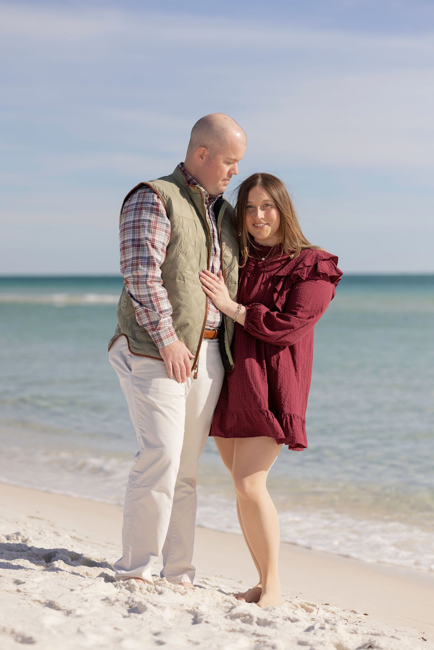 A romantic moment captured between a couple on a pristine beach with turquoise waters behind them.