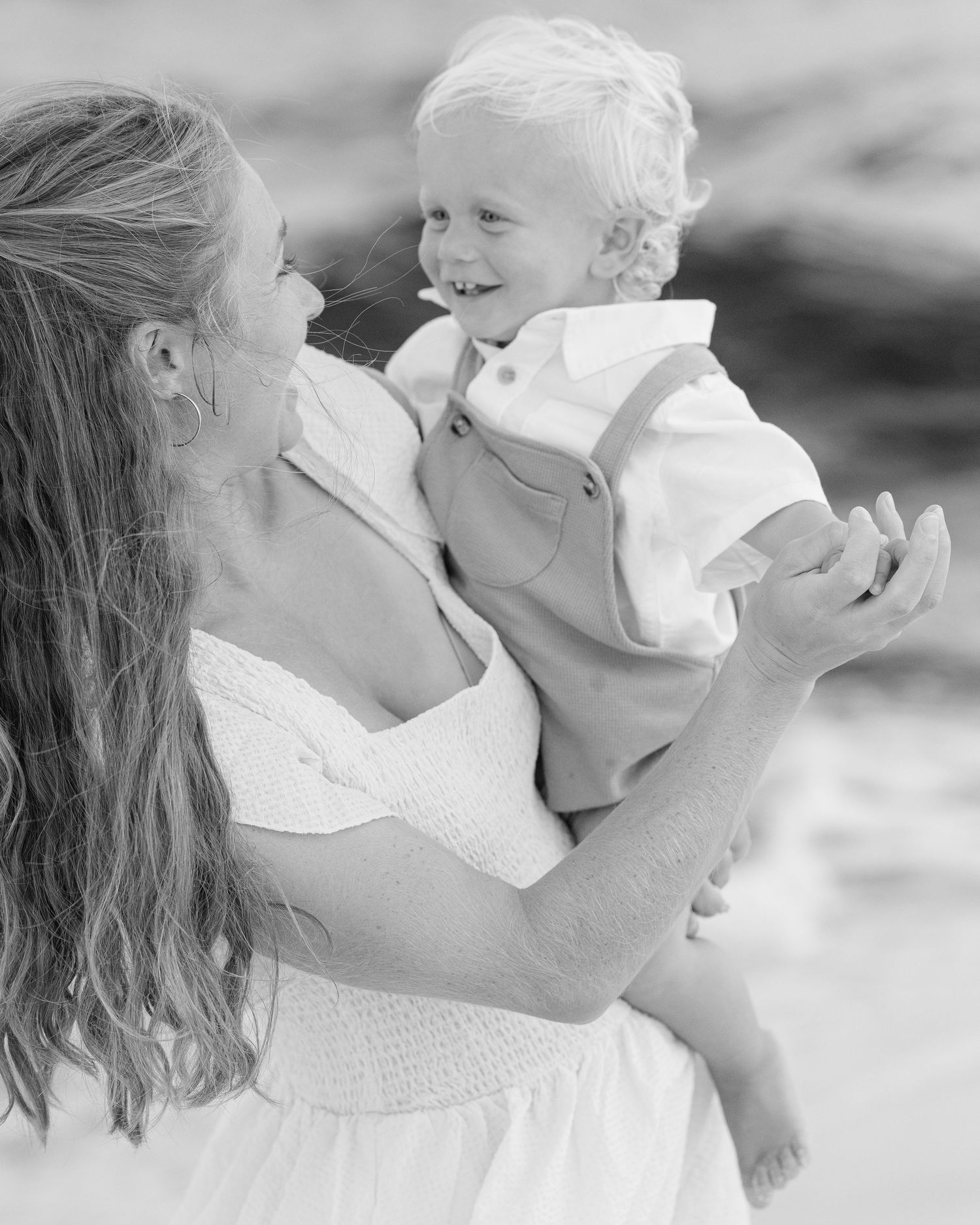 Sweet black and white candid moment between parent and child on the beach.