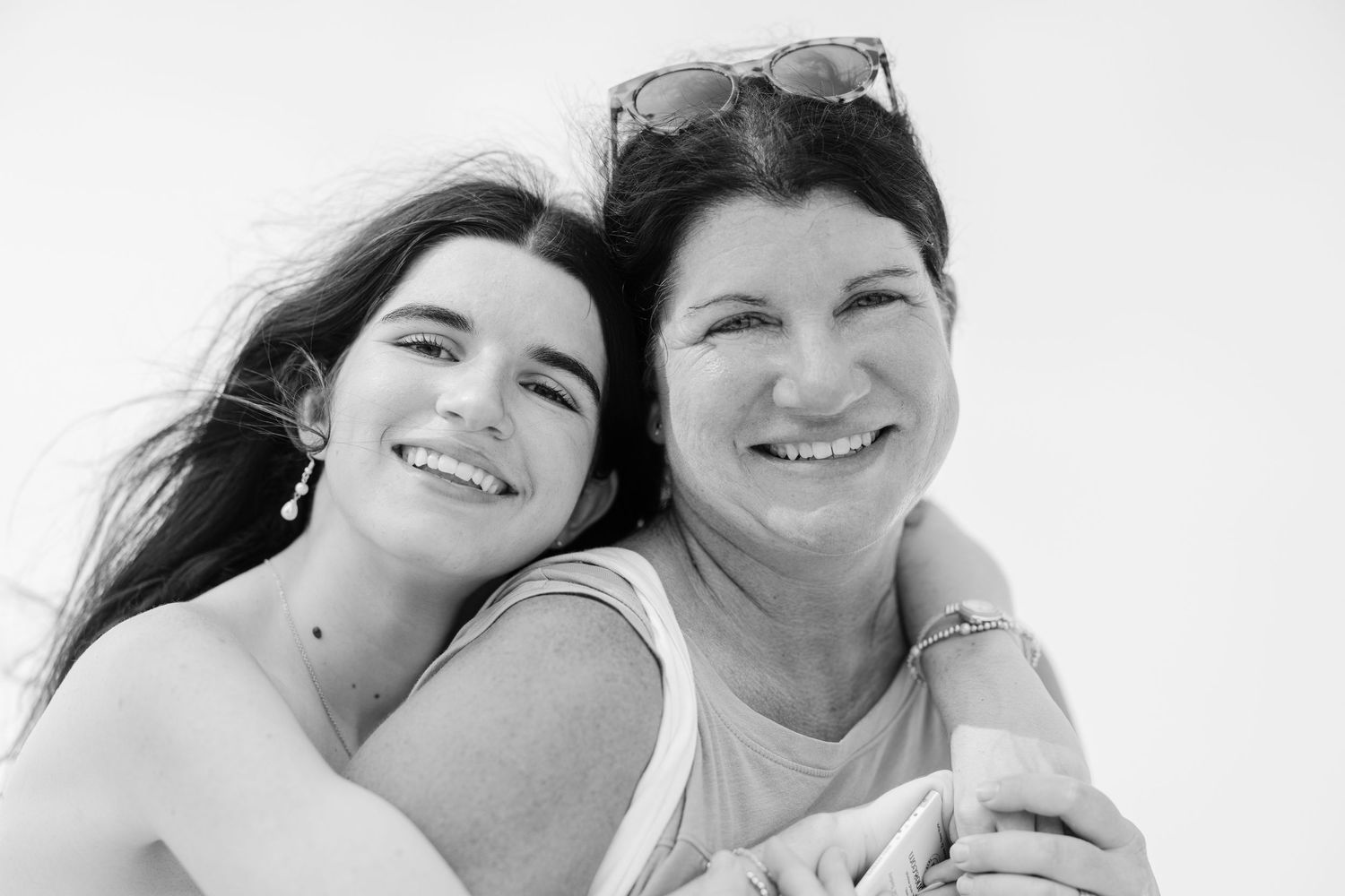 Smiling young woman and older woman posing together in black and white portrait photo.