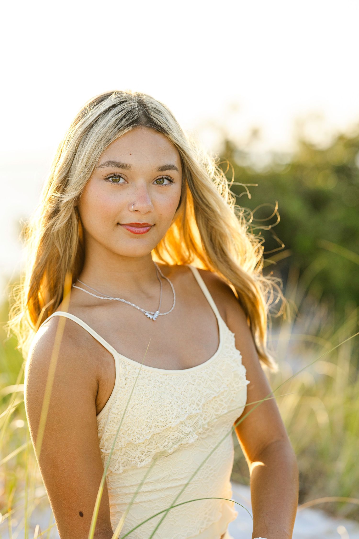 A portrait photo taken outdoors at sunset with warm golden light and a natural background.