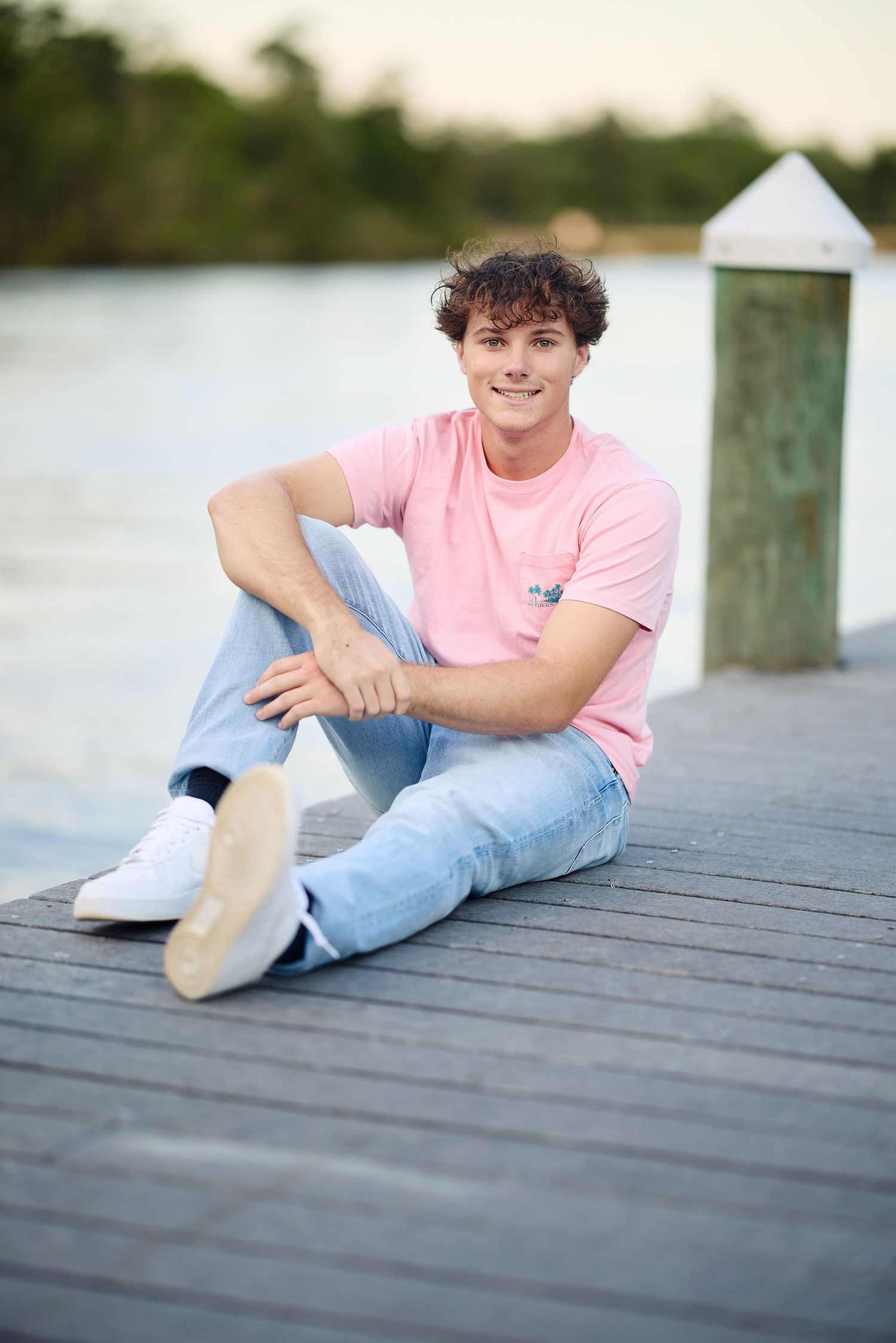 A series of casual portraits taken on a wooden dock showing a person in a pink t-shirt and light denim jeans relaxing.