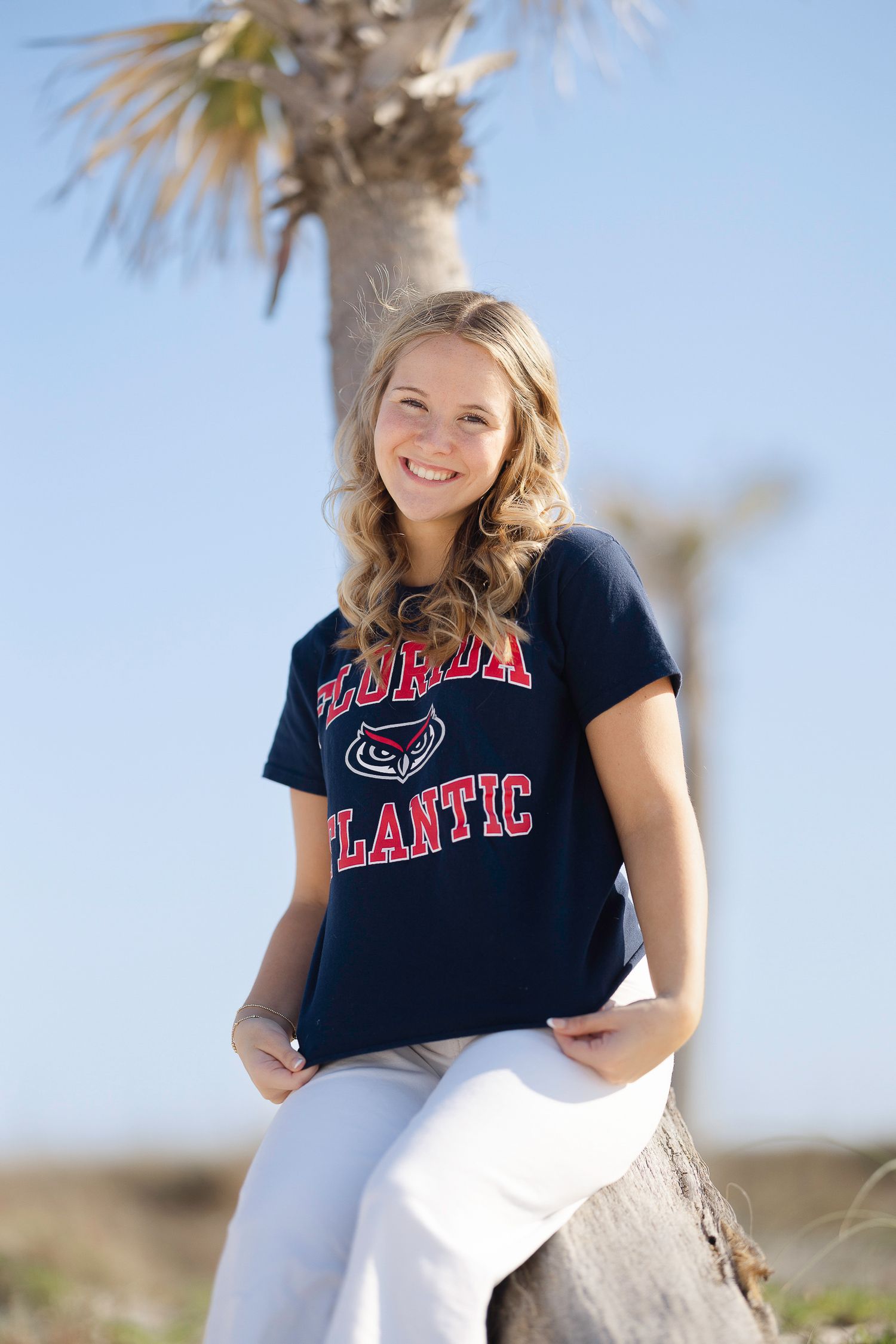 Four outdoor portraits of someone wearing a navy blue t-shirt with red text against a sunny desert landscape background.
