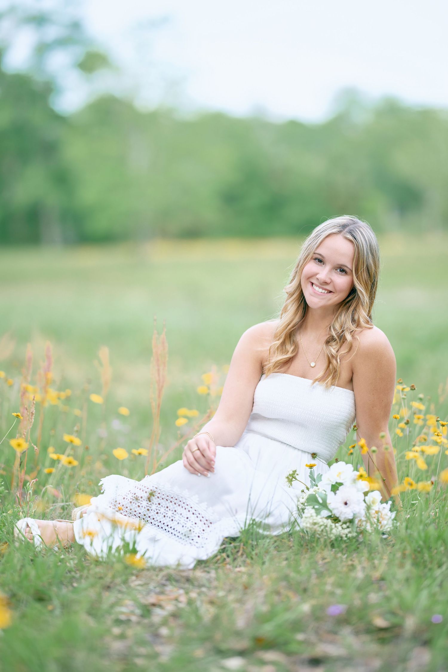 Soft focus portrait in meadow with white dress and flowers.
