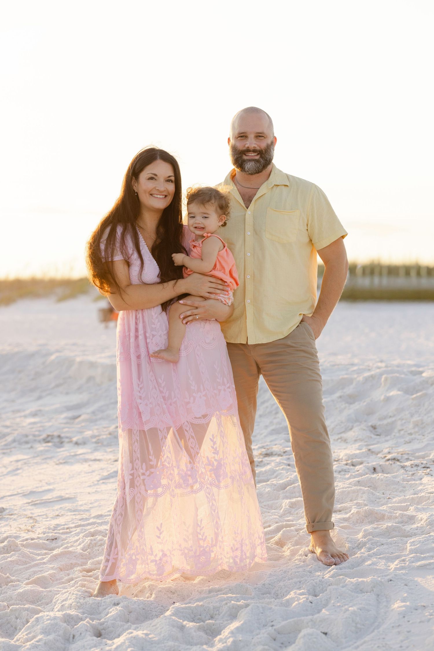 Four candid photos show a family together on a white sandy beach during sunset, creating warm and joyful moments.