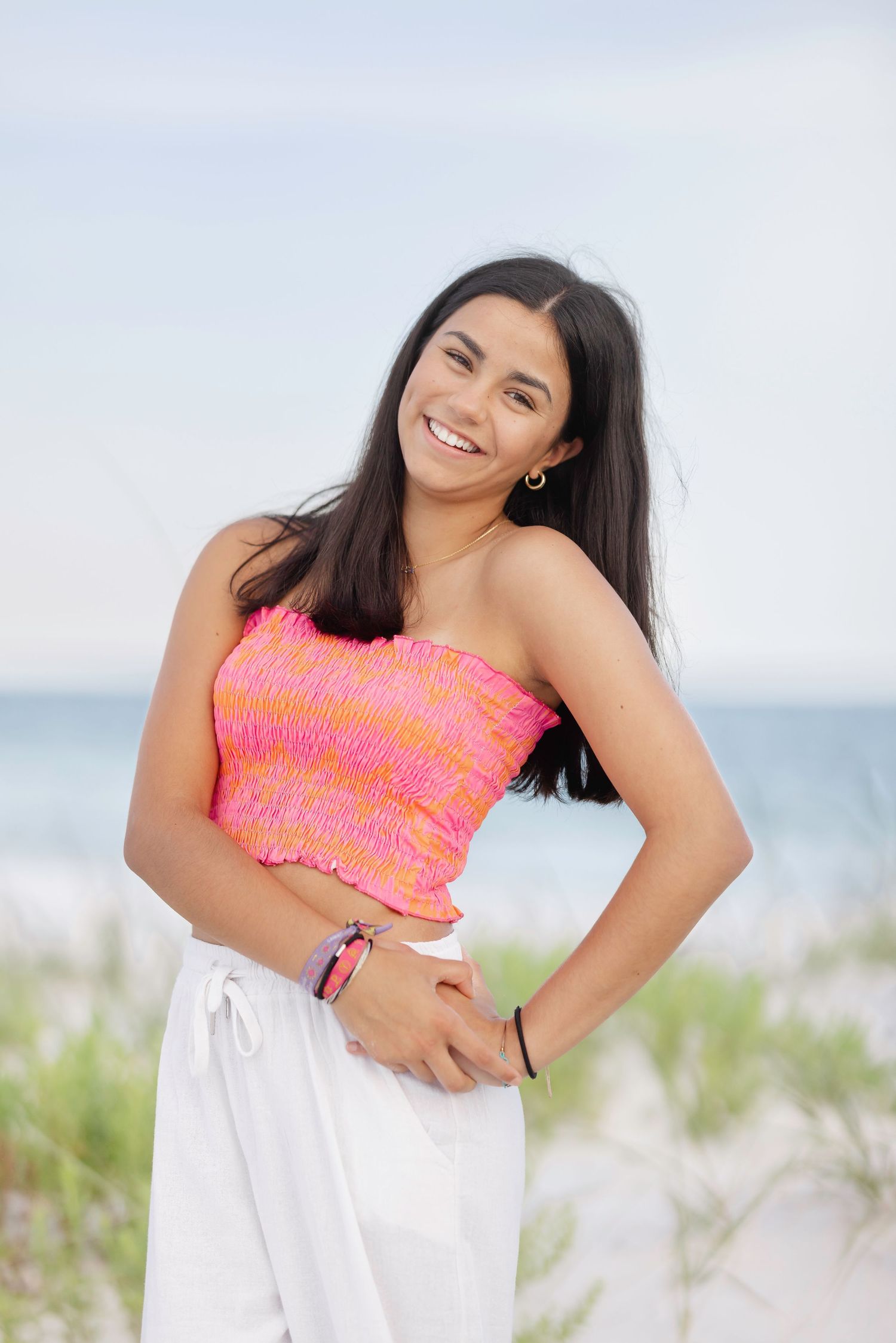 Woman in bright swimwear strikes playful poses against beachy backdrop.