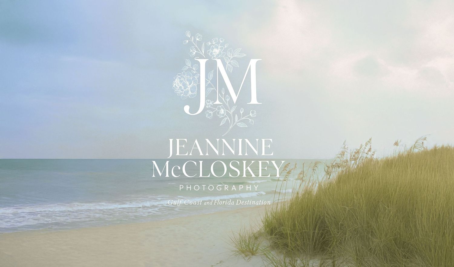 White JM monogram logo design on a dreamy beach landscape with sea grass and ocean waves under cloudy skies.