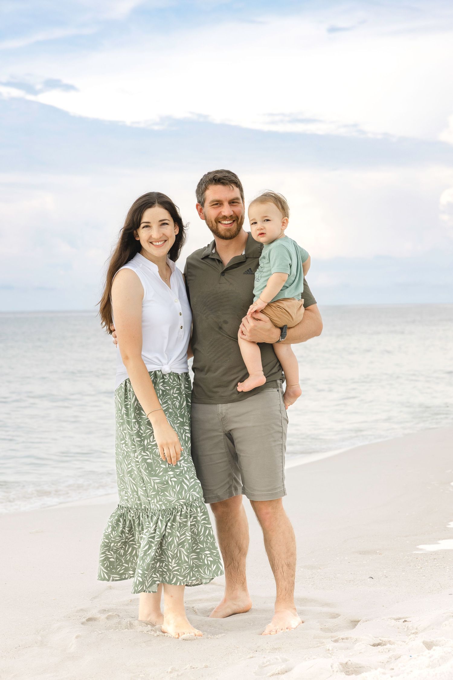 Happy family creates memories during a casual beach photoshoot with light, airy backdrop.