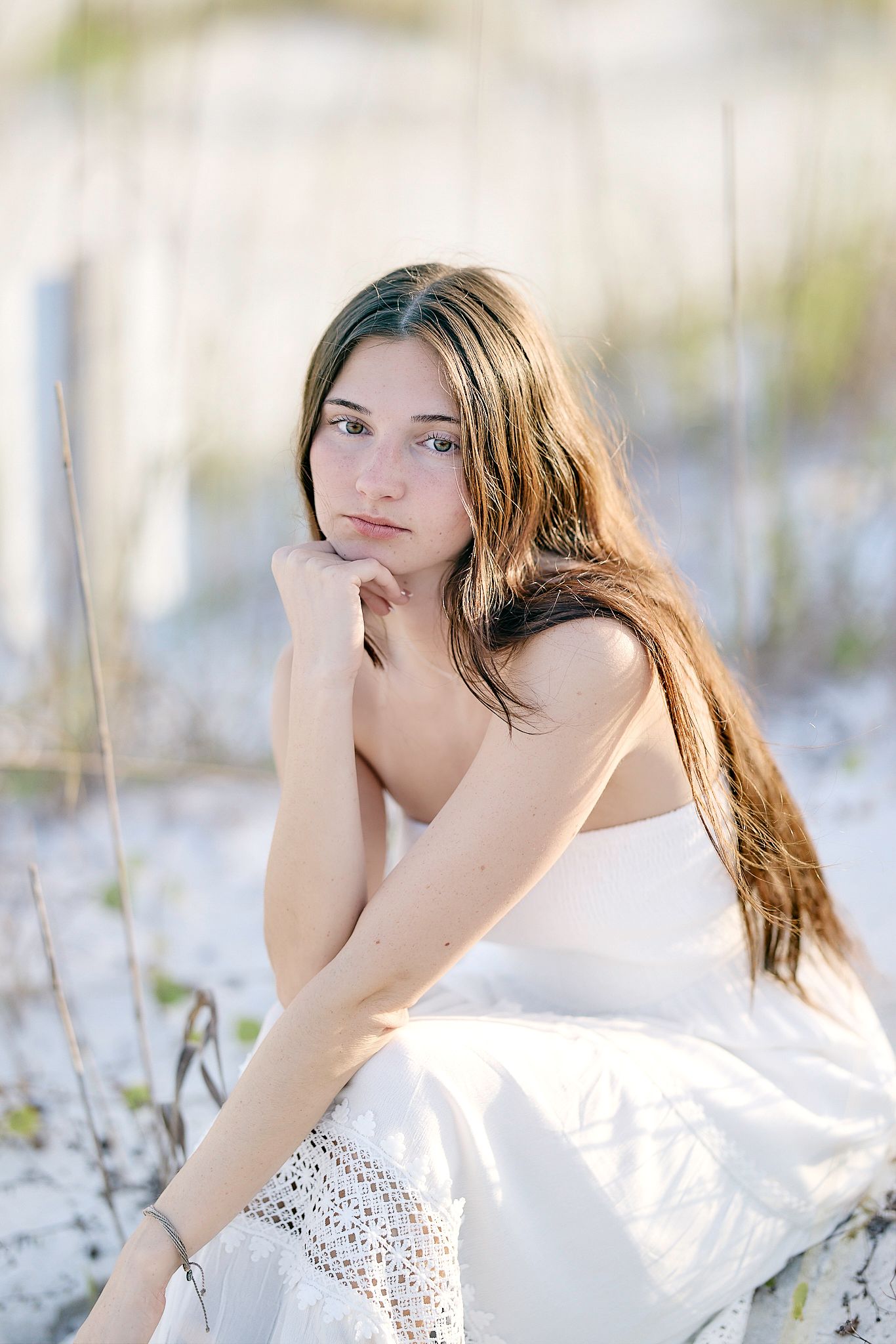 Ethereal outdoor photography features someone in white against a natural backdrop with delicate wildflowers.