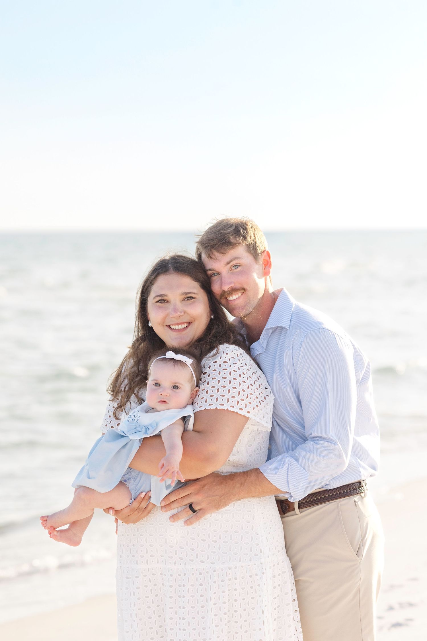Family portrait series on beach with soft natural lighting at sunset.