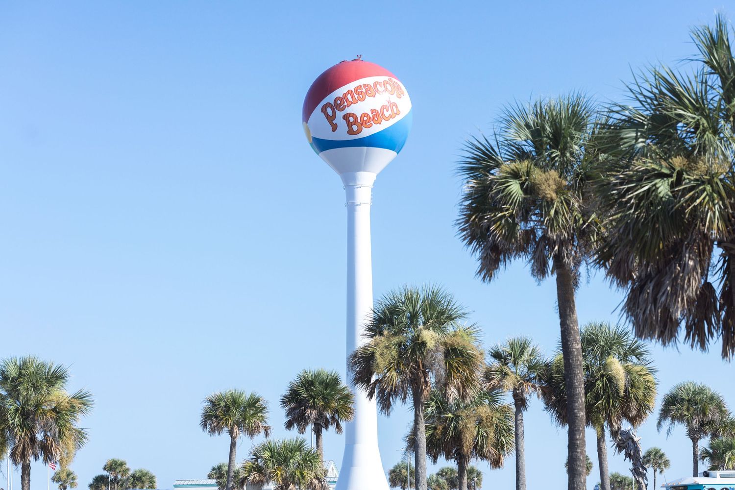 Palm trees line the beach with a water tower and a Sonic Drive-In restaurant sign visible in the distance.