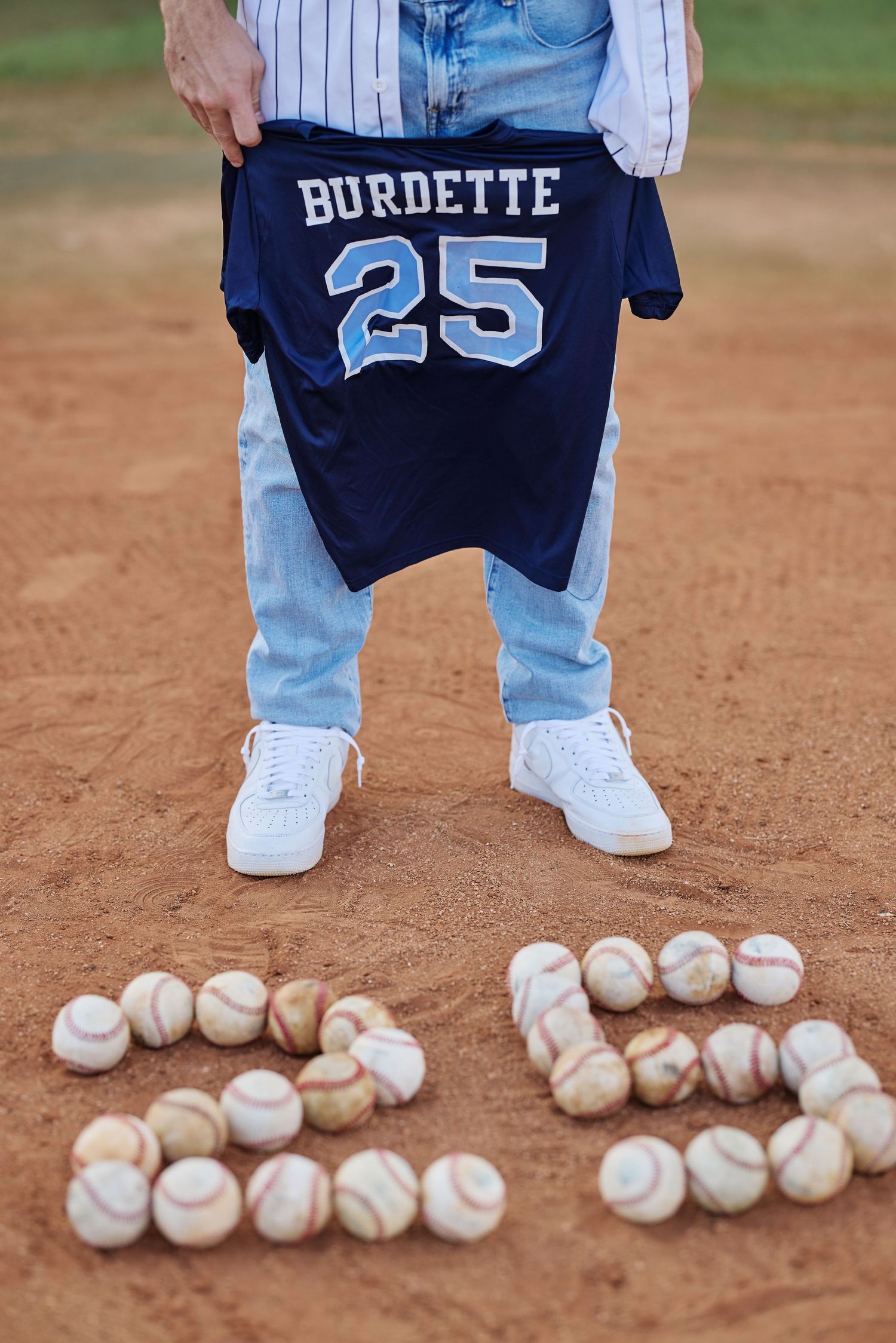 Jersey number 25 Burdette displayed with baseballs arranged in number 25 on baseball field.