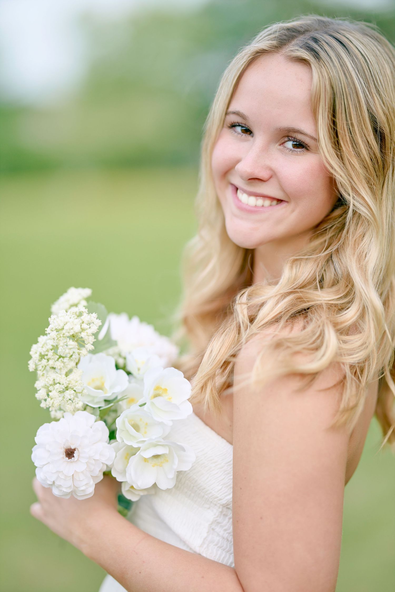 Summer portrait with white bouquet against soft green background.