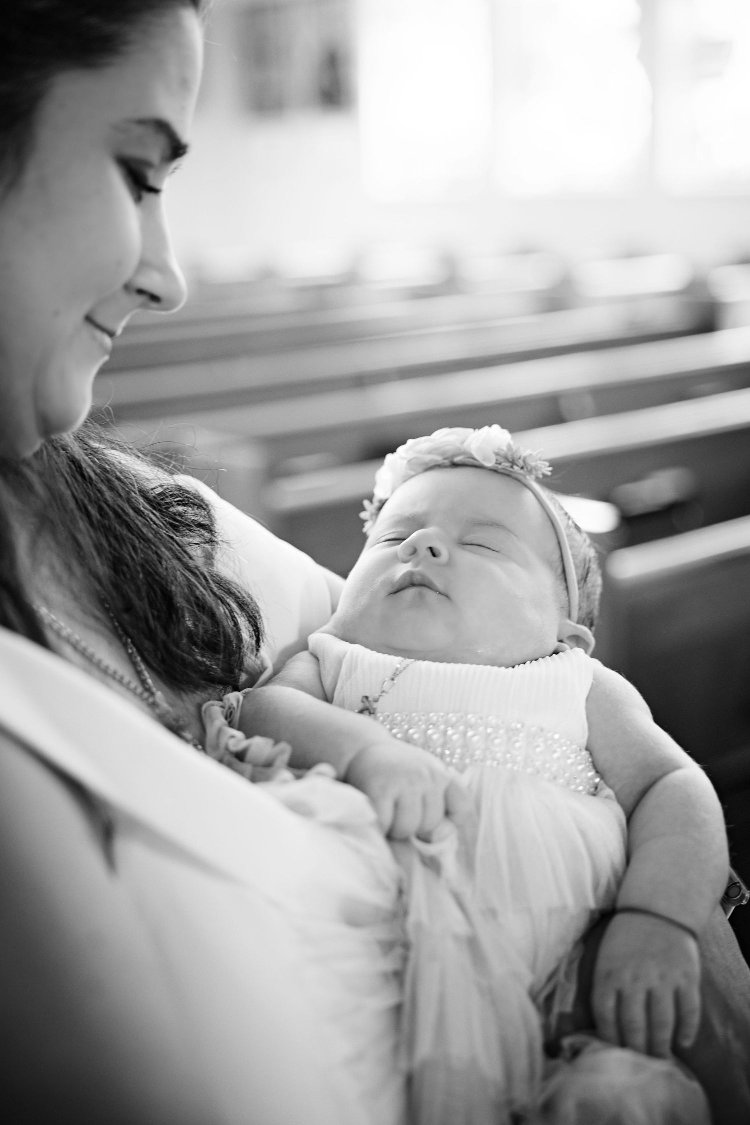 A tender black and white photo series showing a sleeping baby being cradled in someone's arms.
