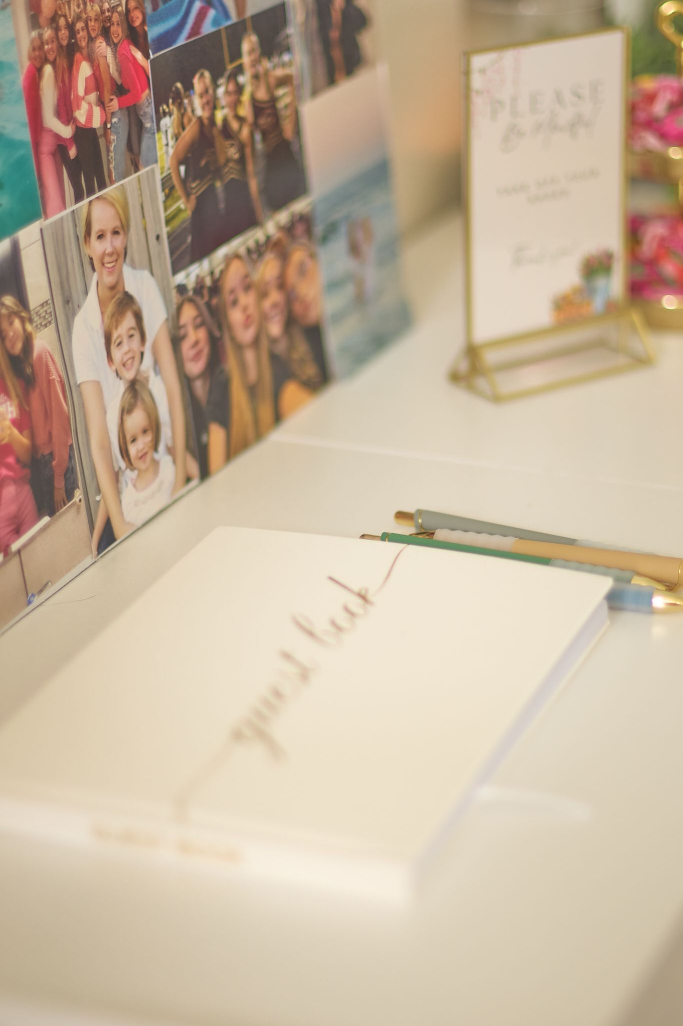 Close-up of a desk with photo collages, pencils, and a notebook in soft focus.