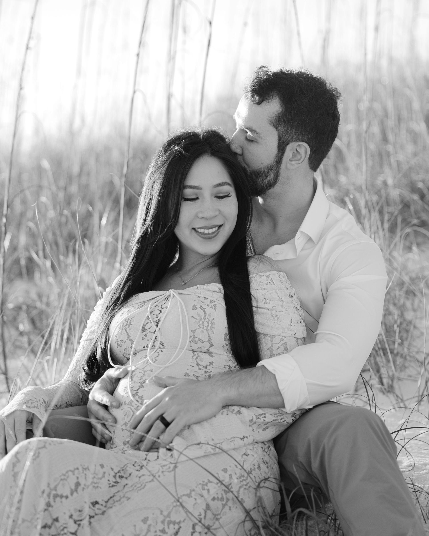 Black and white romantic couple photos in a dreamy beach setting with tall grass.