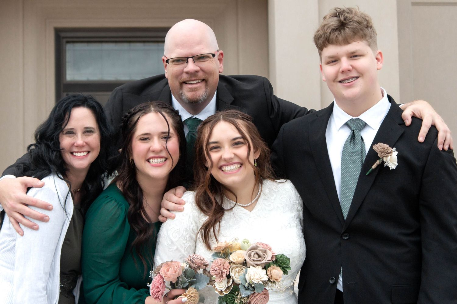 A family standing together sharing a picture together to celebrate this day filled with joy and love.