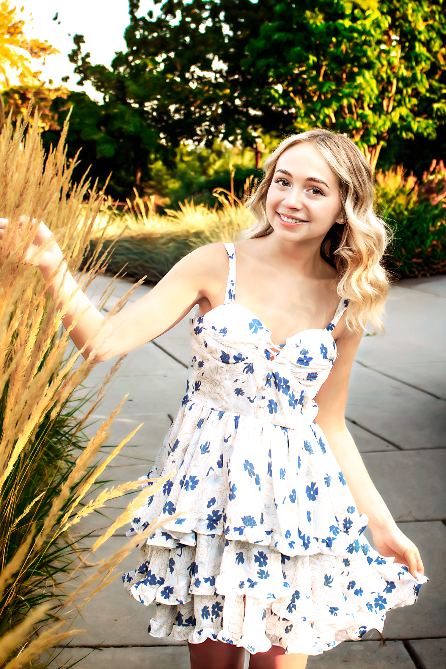 Dancing and twirling in a floral sundress against a garden landscape with golden light.