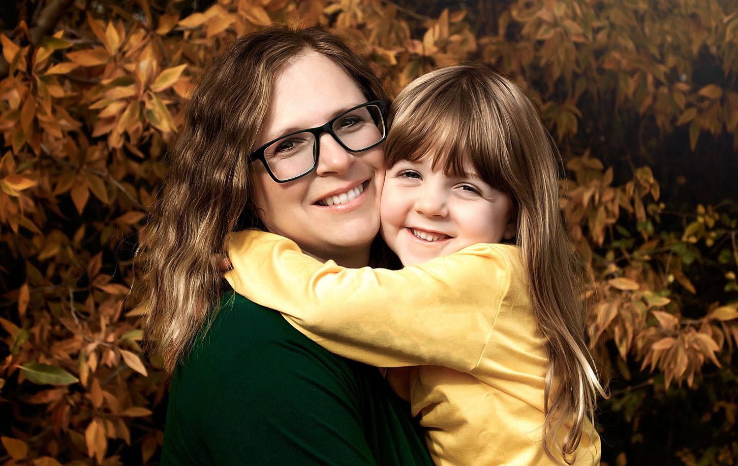 Warm autumn portrait with golden leaves in the background.