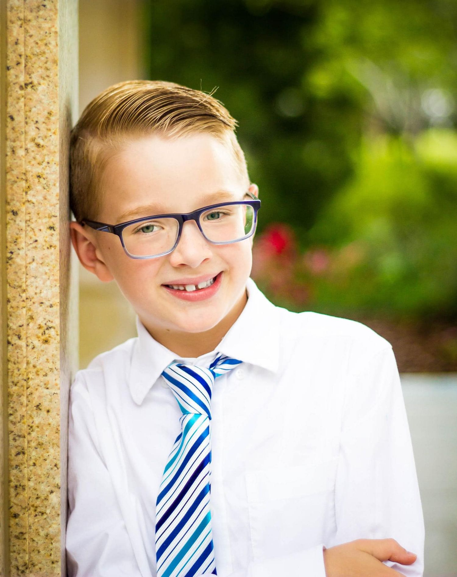 Person wearing glasses and striped tie in formal attire.