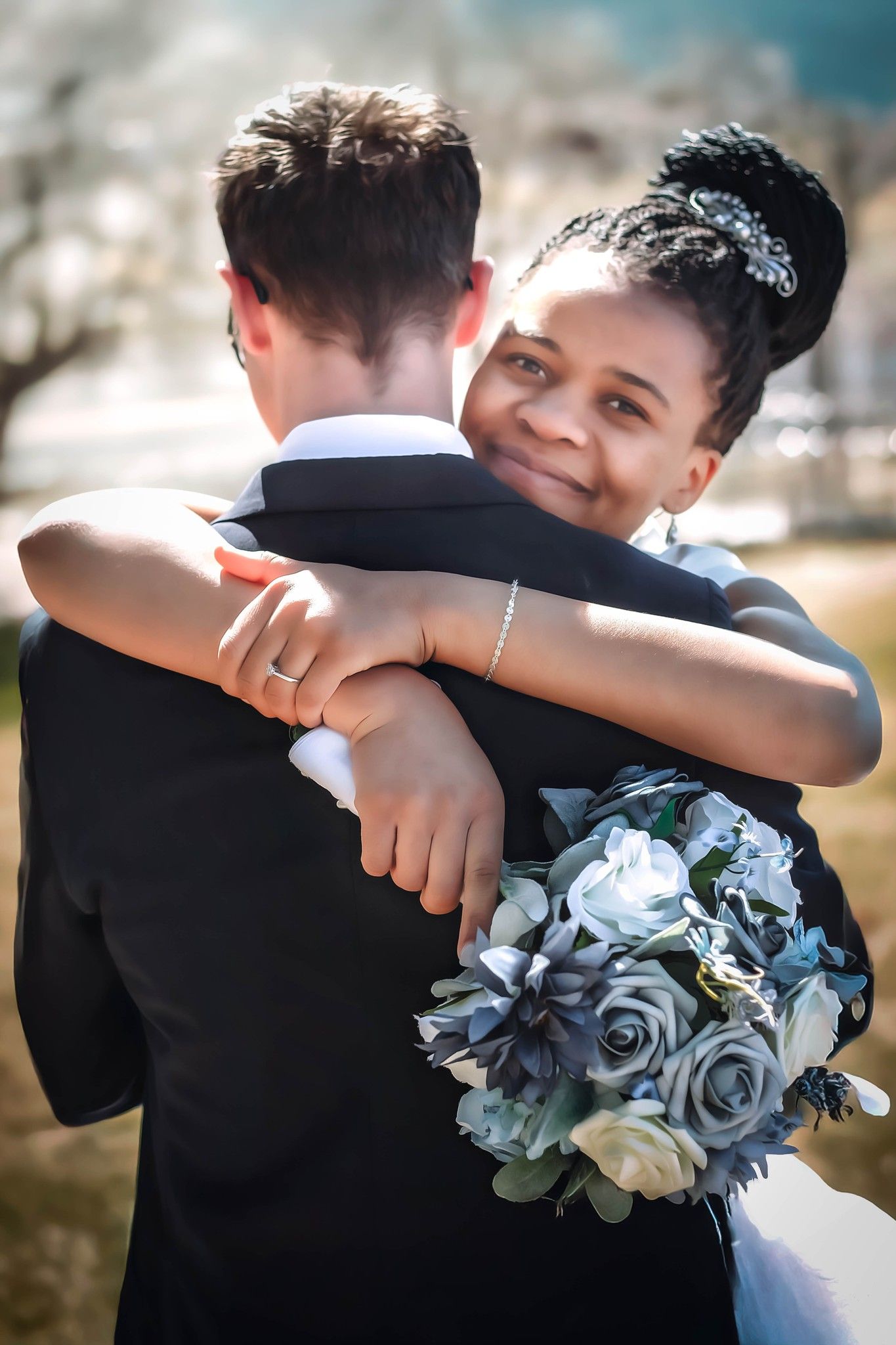 A tender wedding moment captured with blue roses in the bride's bouquet.