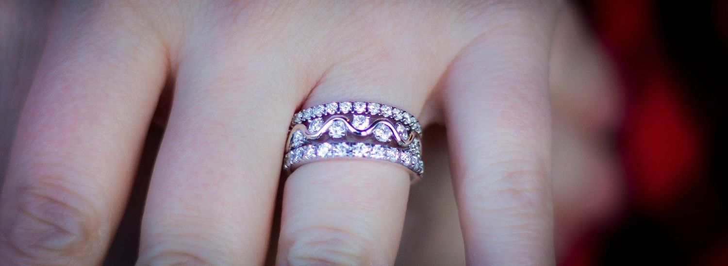 Sparkling diamond wedding rings stacked together on a finger.