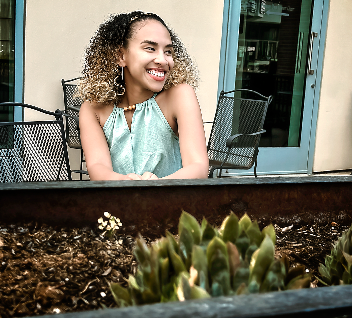 Casual outdoor portrait session featuring a mint green outfit against modern architecture.