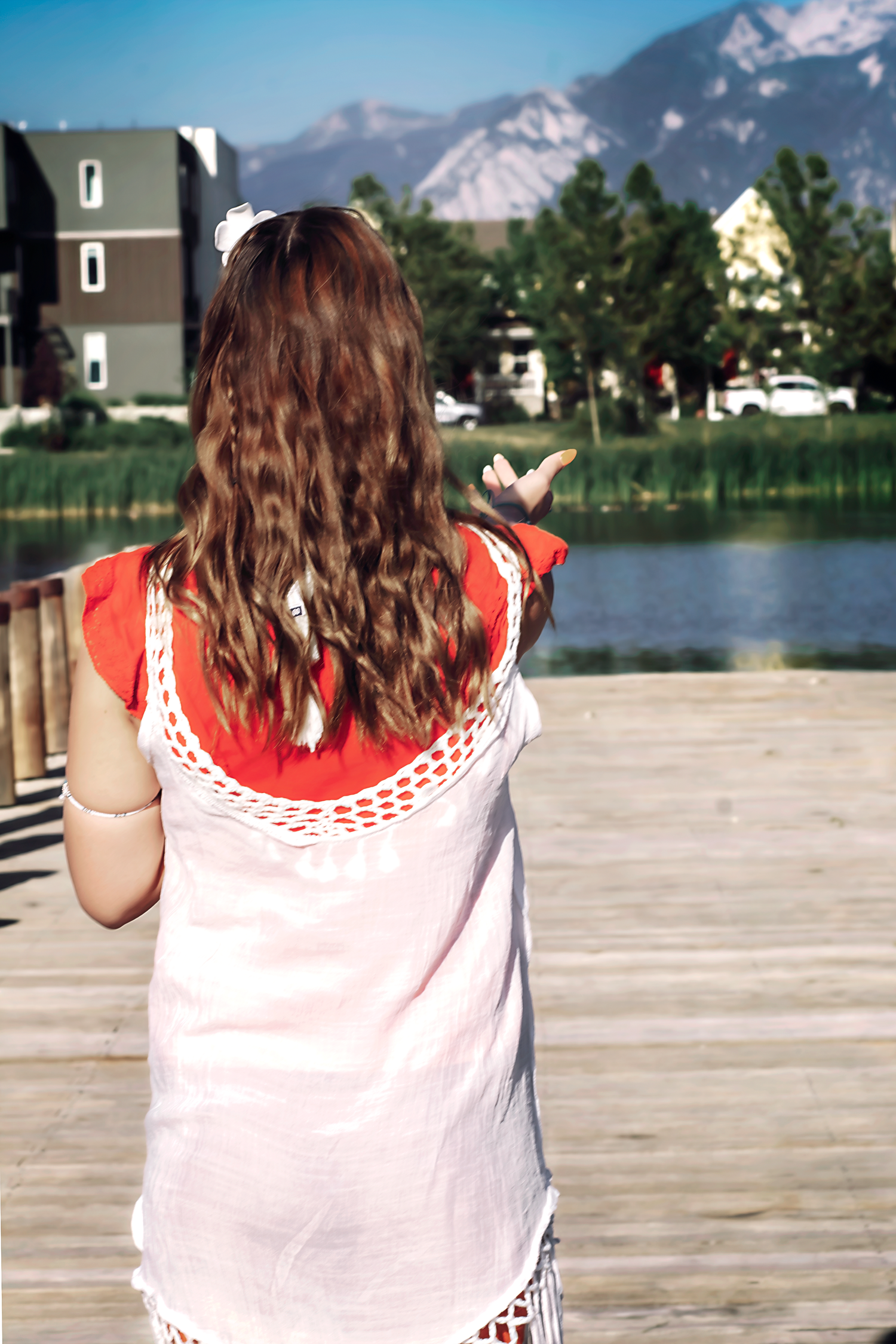 White summer top with coral trim against mountain landscape.