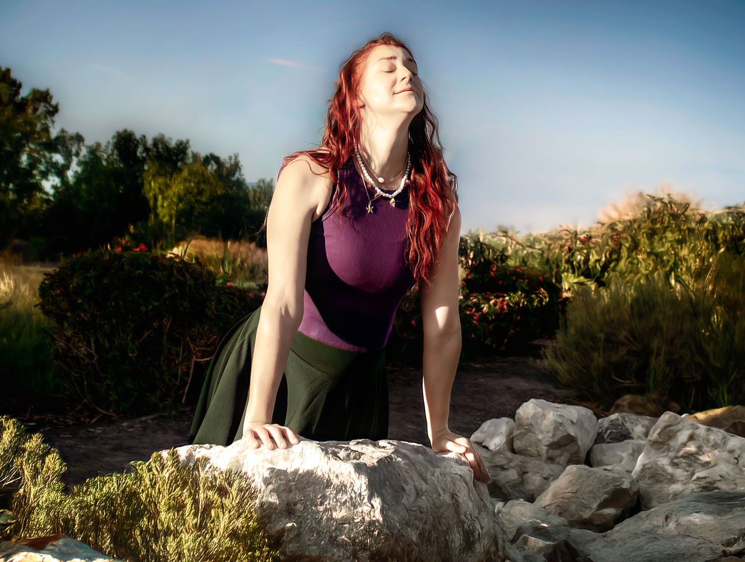 Someone posing on rocky terrain against a bright blue sky backdrop.