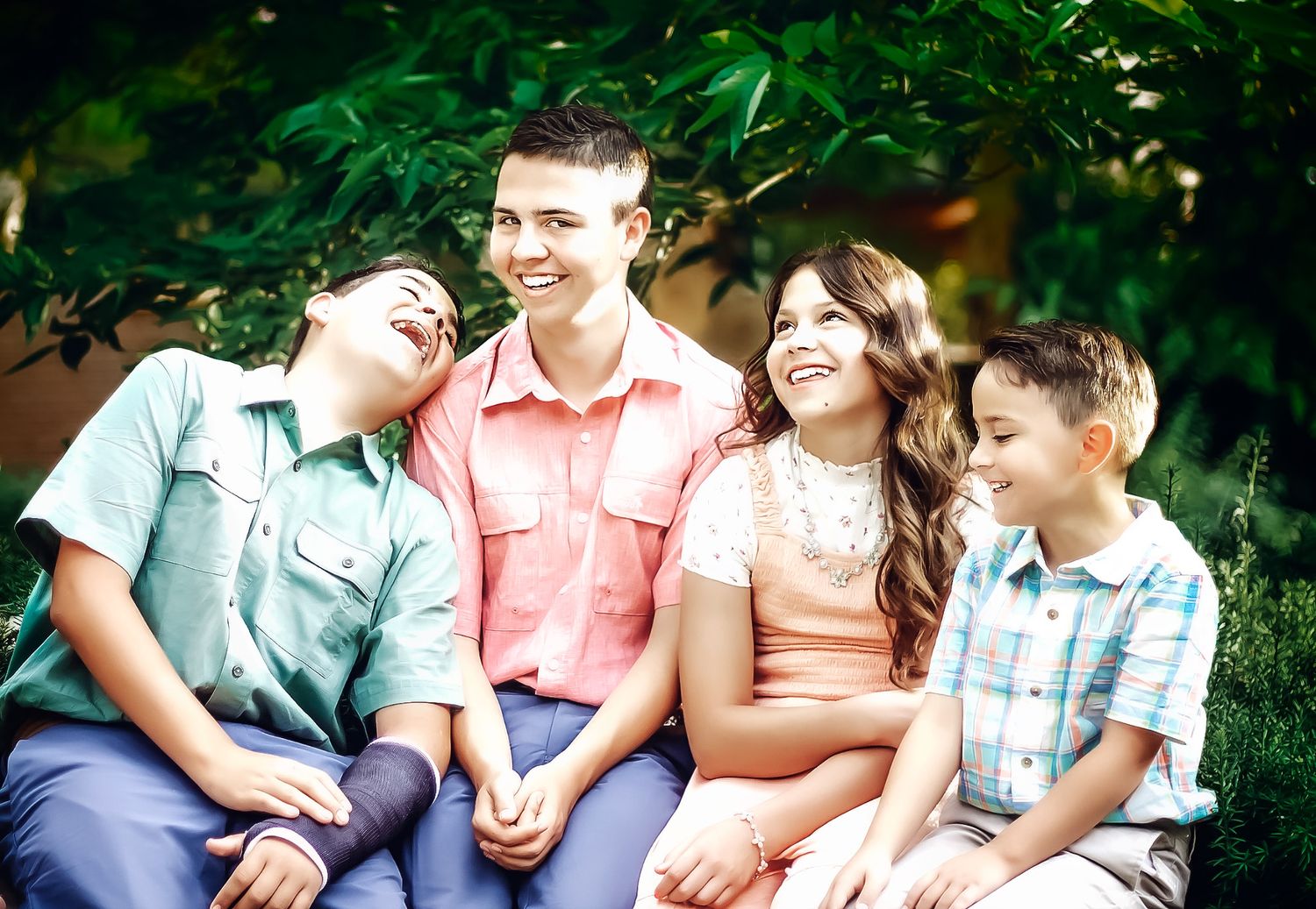 Family members sitting together and laughing during casual outdoor photo session.